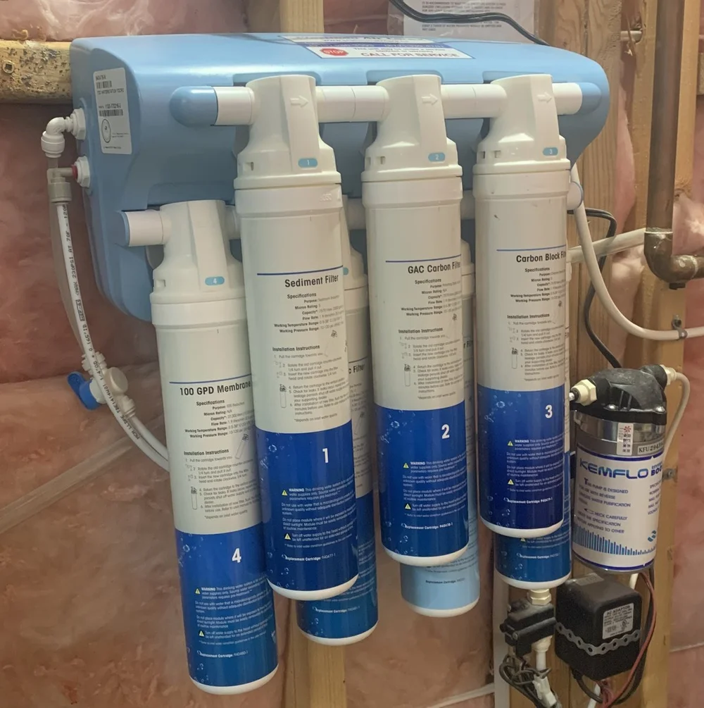 7-stage reverse osmosis system mounted on a basement wall, with its sediment, carbon, and membrane filters numbered 1 to 4