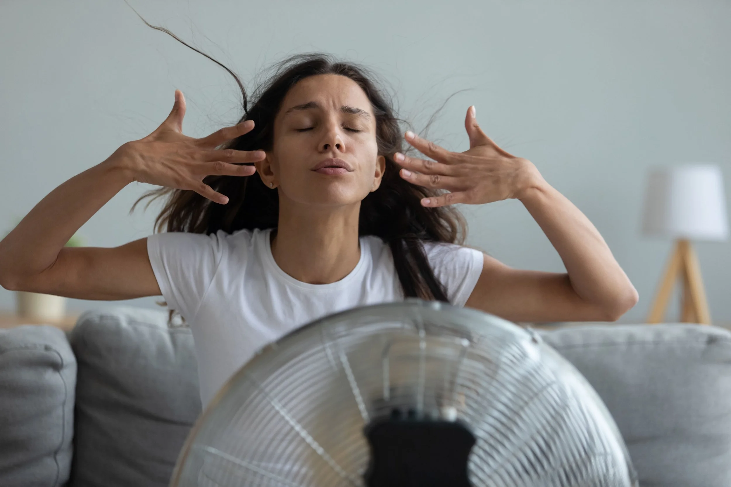 Person using fan while waiting for air conditioning repair