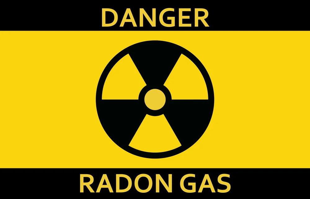 Yellow and black warning sign with a radiation symbol, reading Danger Radon Gas