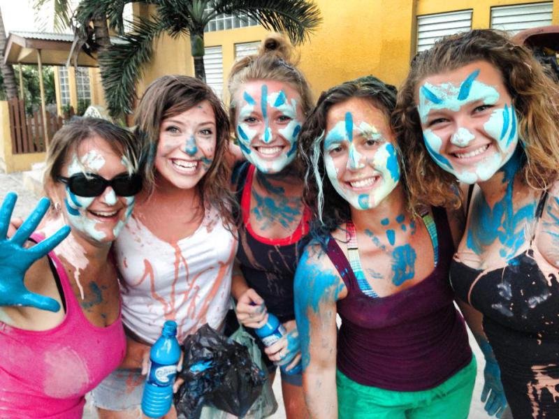 A group of travelers celebrating El Gran Carnaval in San Pedro, Belize, with traditional blue face paint.