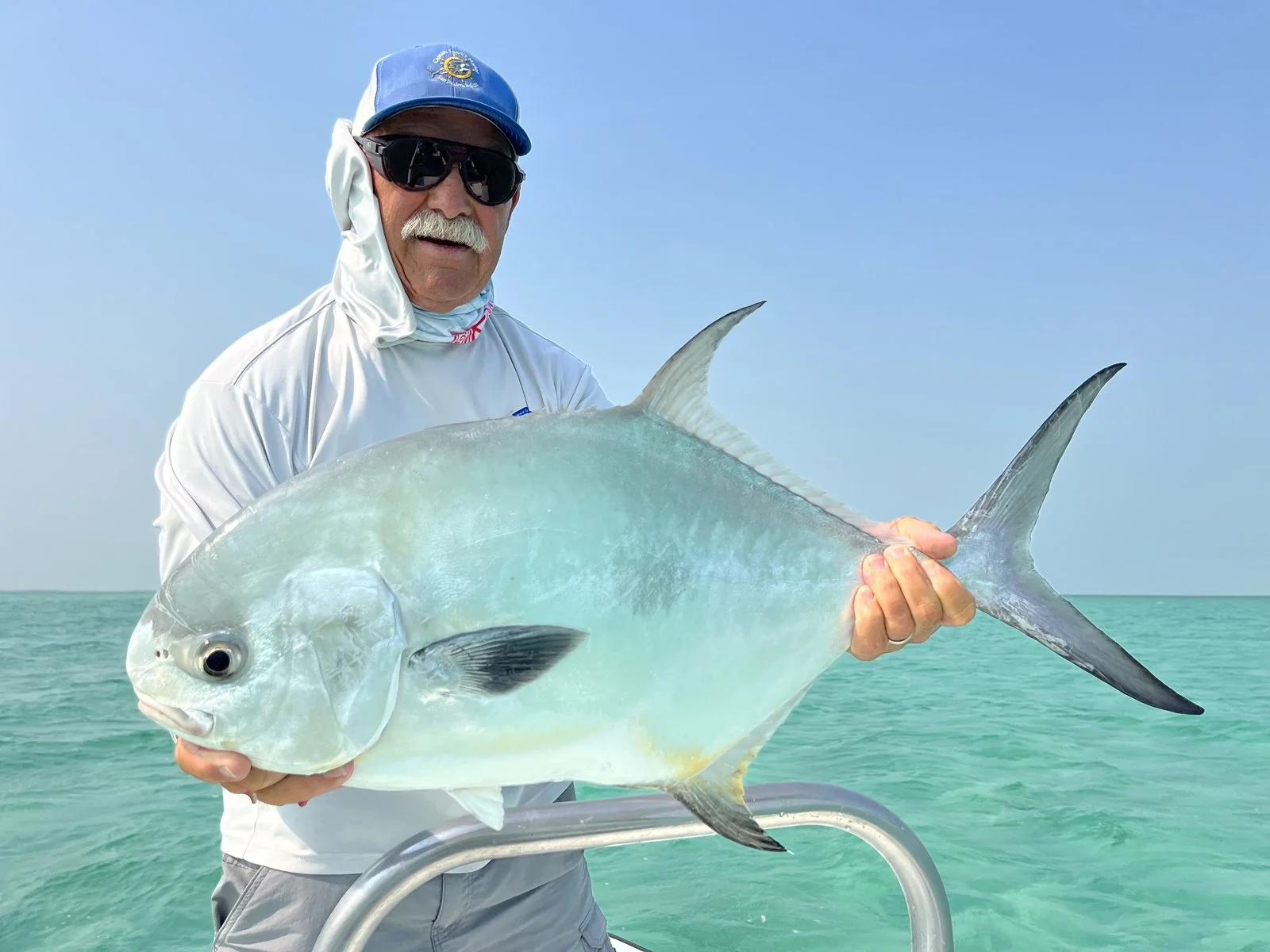 World-record fly fisherman Ken Watkins holding a trophy Permit caught in San Pedro while staying at The Phoenix Resort.