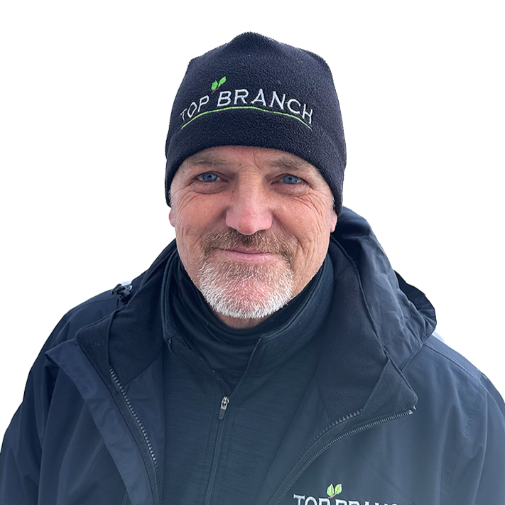 Top Branch member Tracy Chaplin dressed in top branch tree service uniform against white back ground for apple tree pruning class