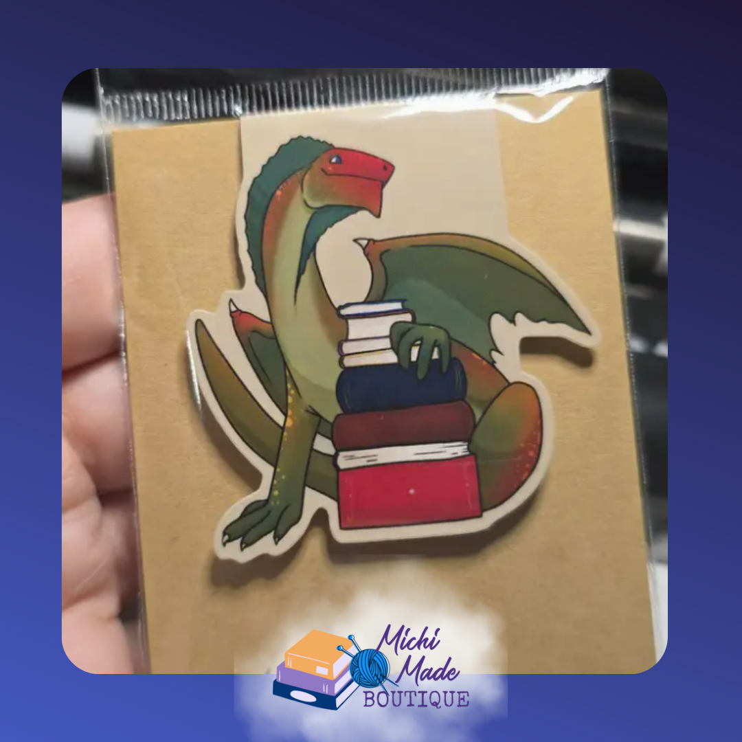 Small green dragon holding a neat pile of books.