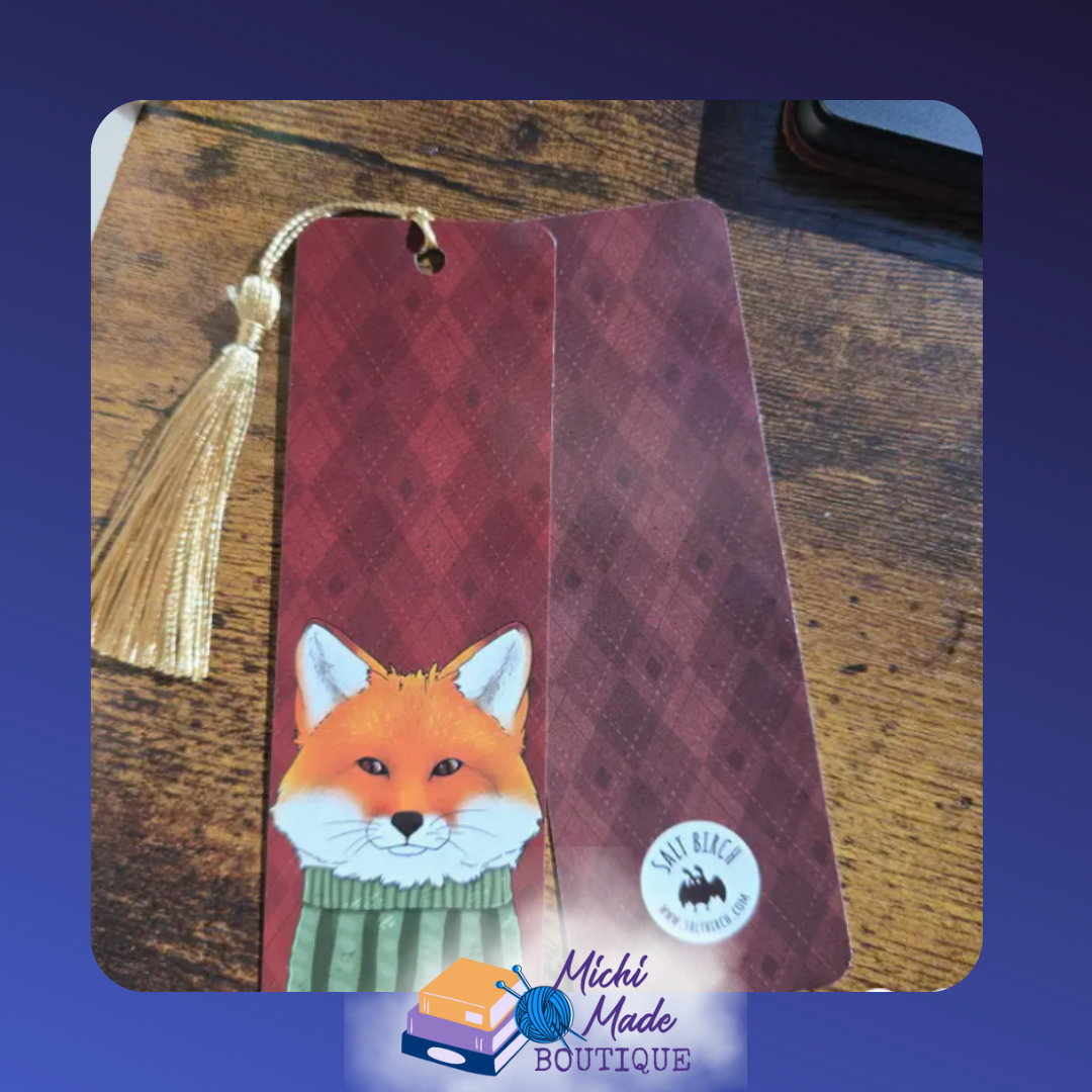 2"x6" bookmark with fox in scarf on red argyle background, gold tassel attached.