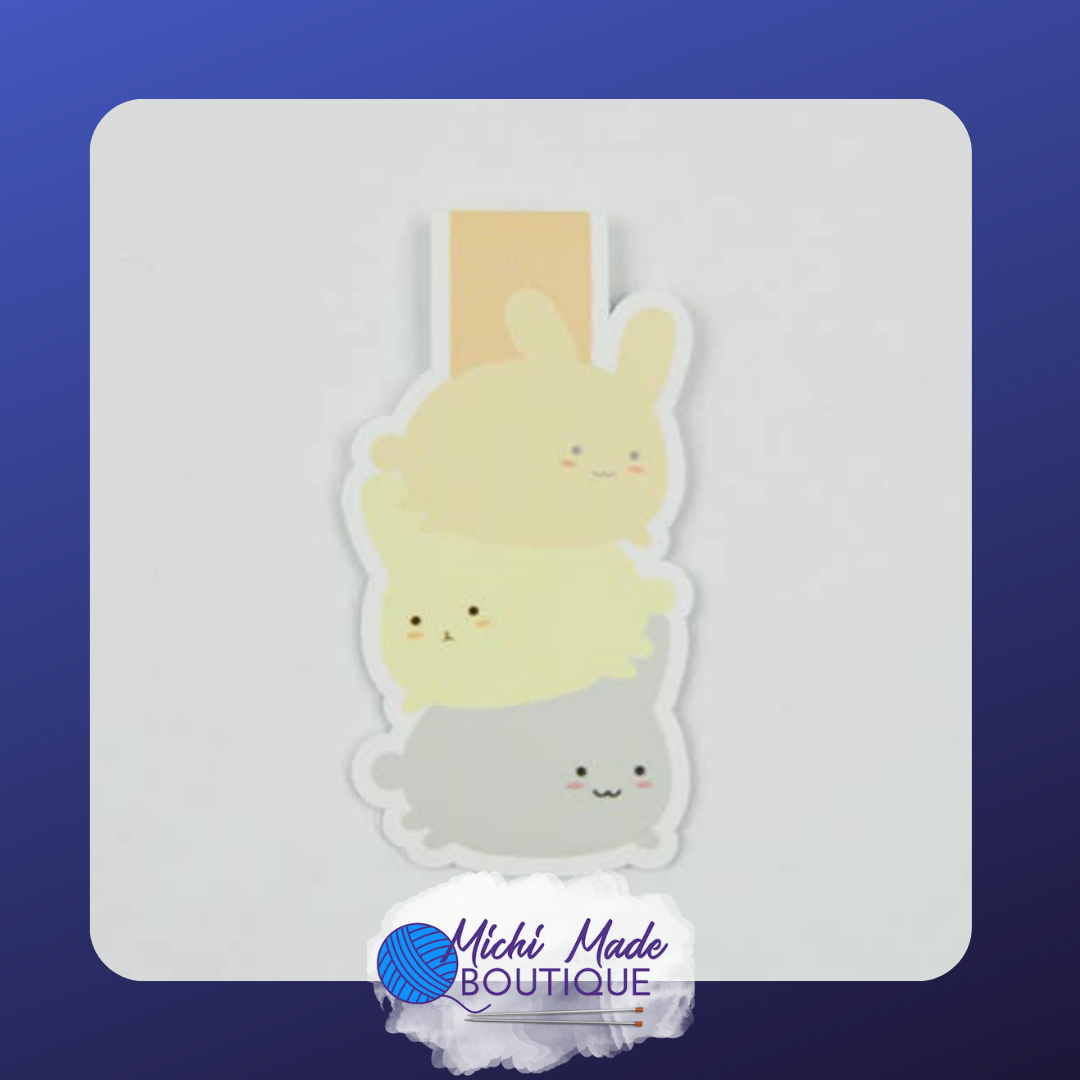 Magnetic bookmark of three stacked pastel bunnies with round faces and tiny blush marks.