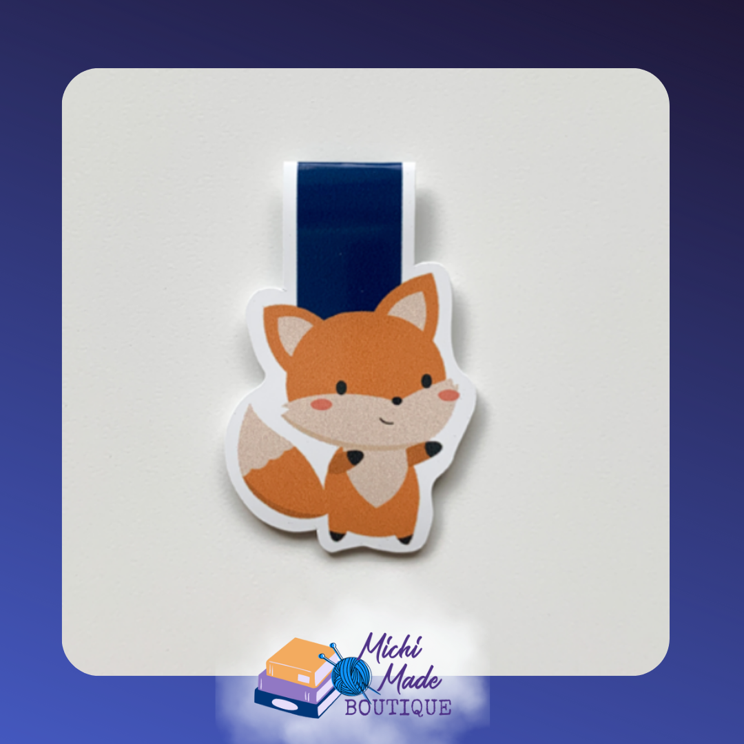 Cute fox magnetic bookmark with rosy cheeks and a dark blue strap.