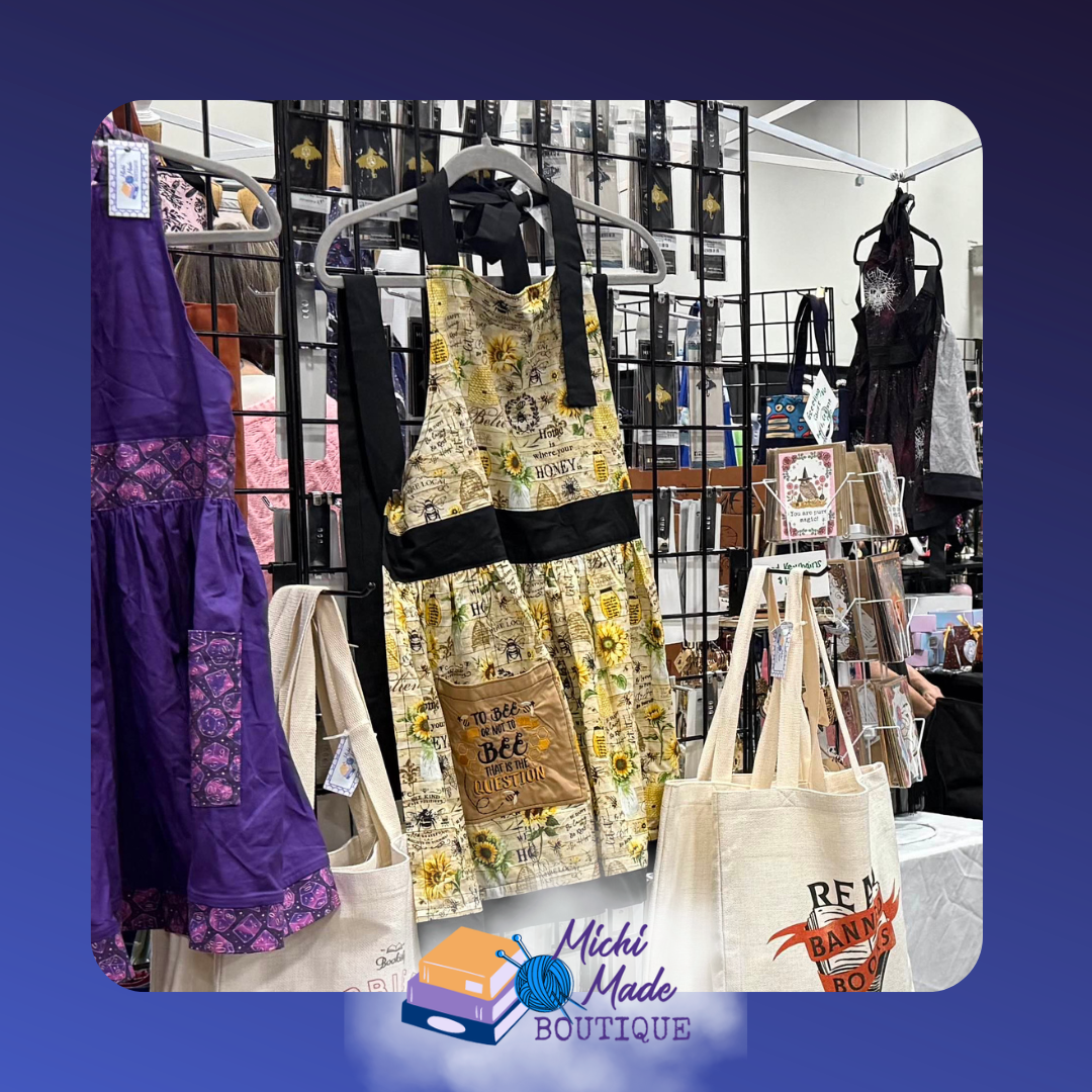 Honeybee Apron - yellow fabric with honeybee print and mustard yellow pockets. Black waistband and straps. To Bee Or Not To Bee embroidered on side pockets.