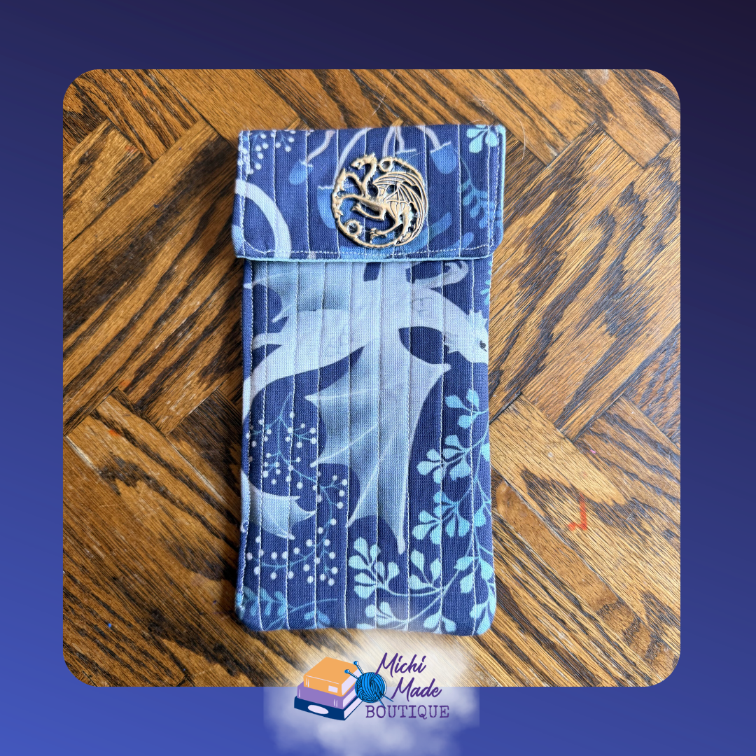Dragon Foliage Eyeglass Case.png Quilted eyeglass case in navy blue with white serpentine dragons and botanical foliage print, decorated with a round silver dragon medallion button.