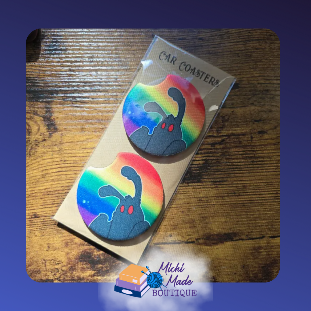 Set of two round car coasters with a black Mothman design on a rainbow gradient background.