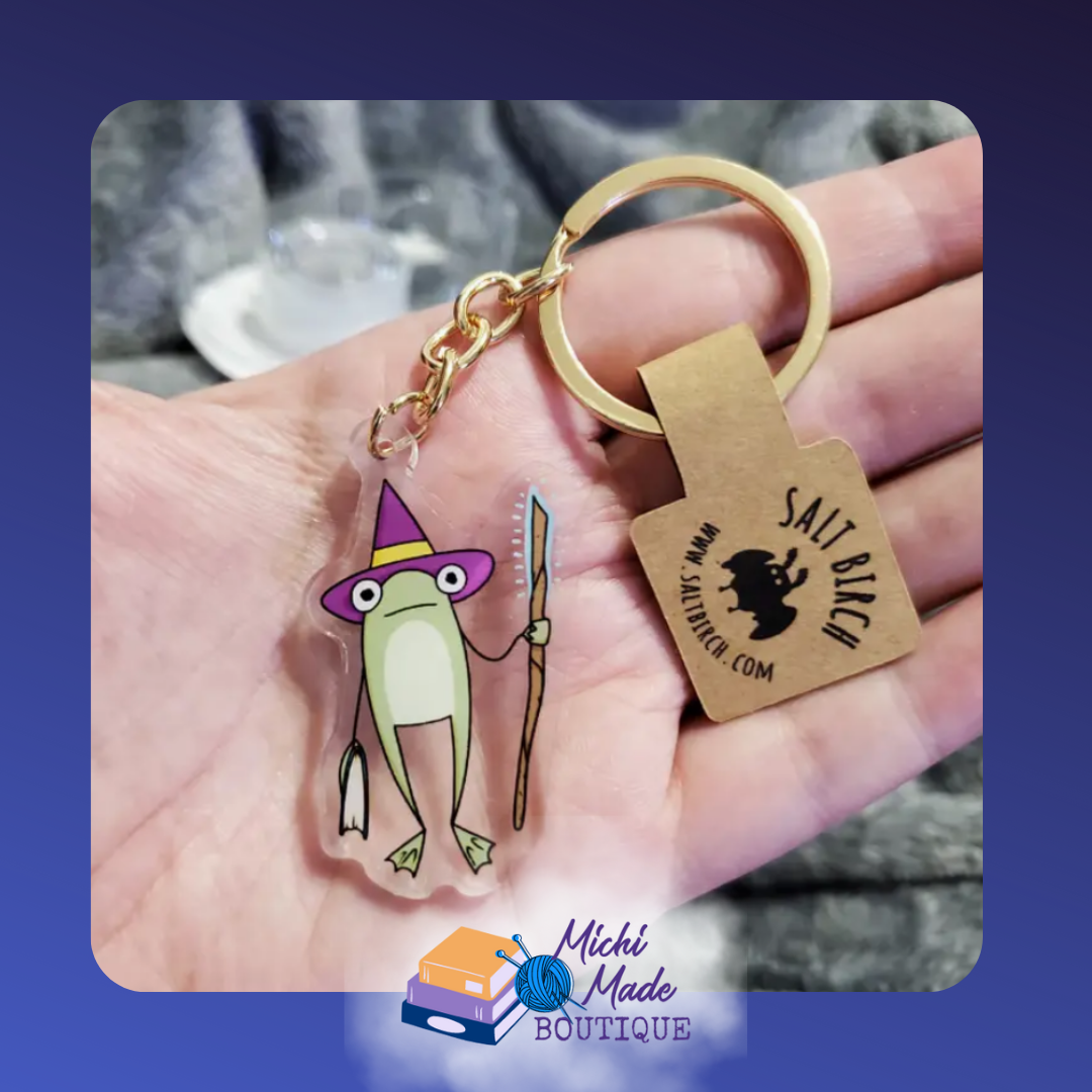 Wizard frog keychain in purple hat holding staff.