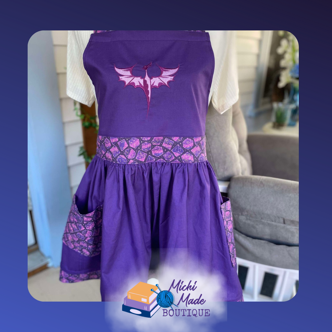 Purple Dice Dragon Apron - purple apron with purple dice fabric trim and waistband. Side pockets have purple dice and a light purple dragon is embroidered on the bib.