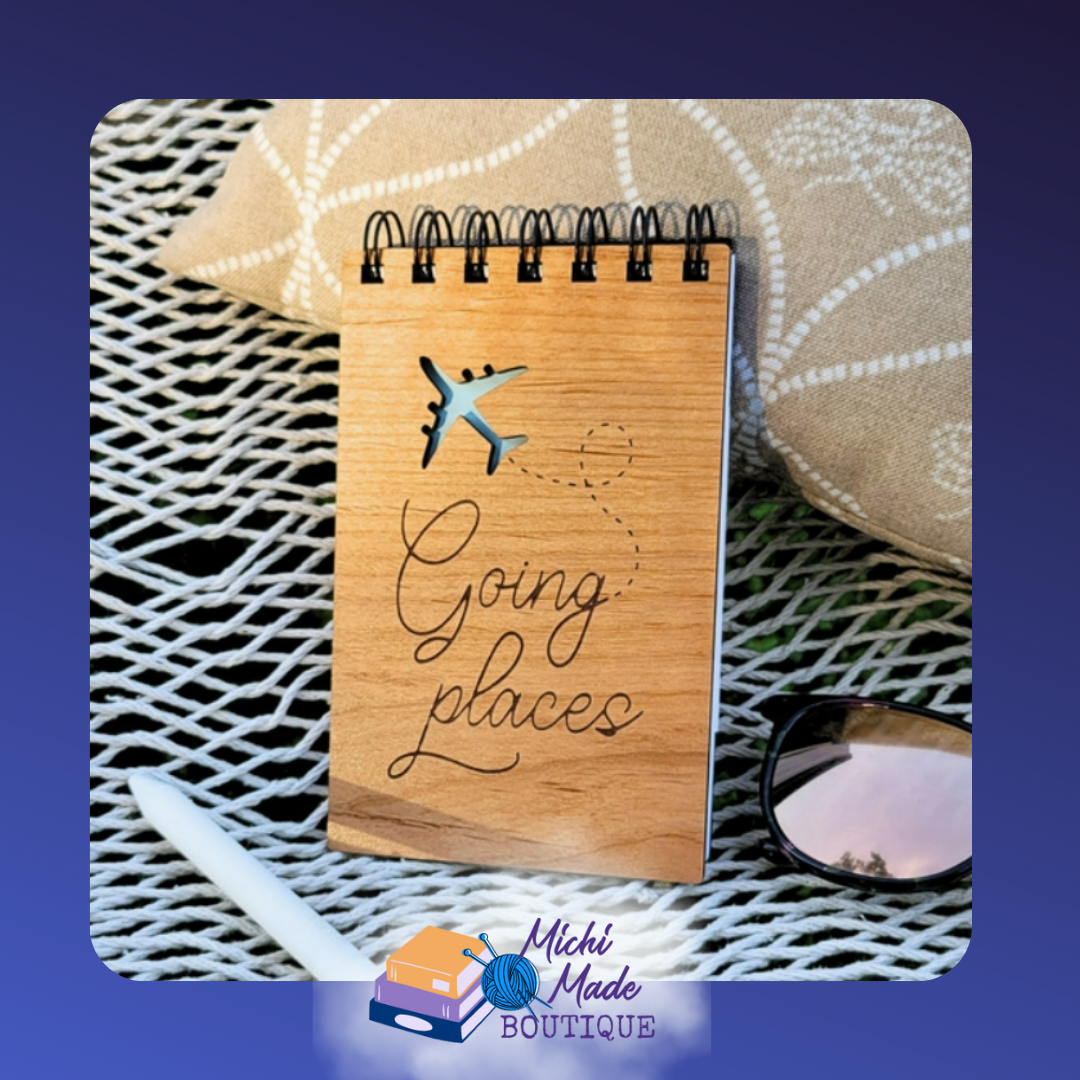 Small wood-cover notepad engraved with “Going Places” and airplane cutout.