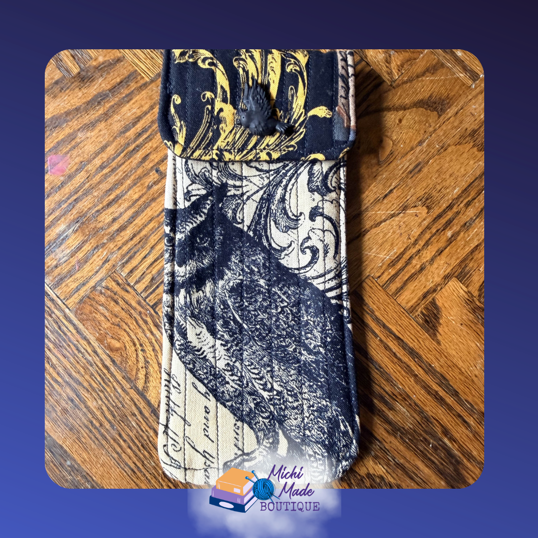 Gothic Cat Case.png Quilted eyeglass case in aged parchment cream with a large black owl and gold baroque flourishes, black flap, and black raven button.