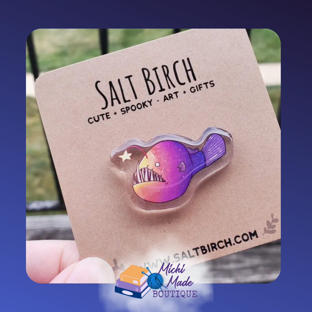 Acrylic pin of a colorful angler fish with glowing lure.