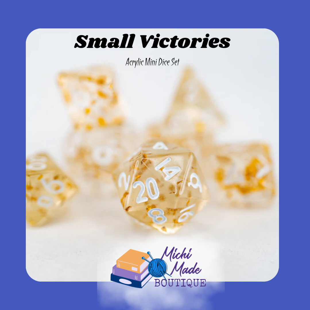 Small Victories — Clear mini dice with gold flakes and white numbers.