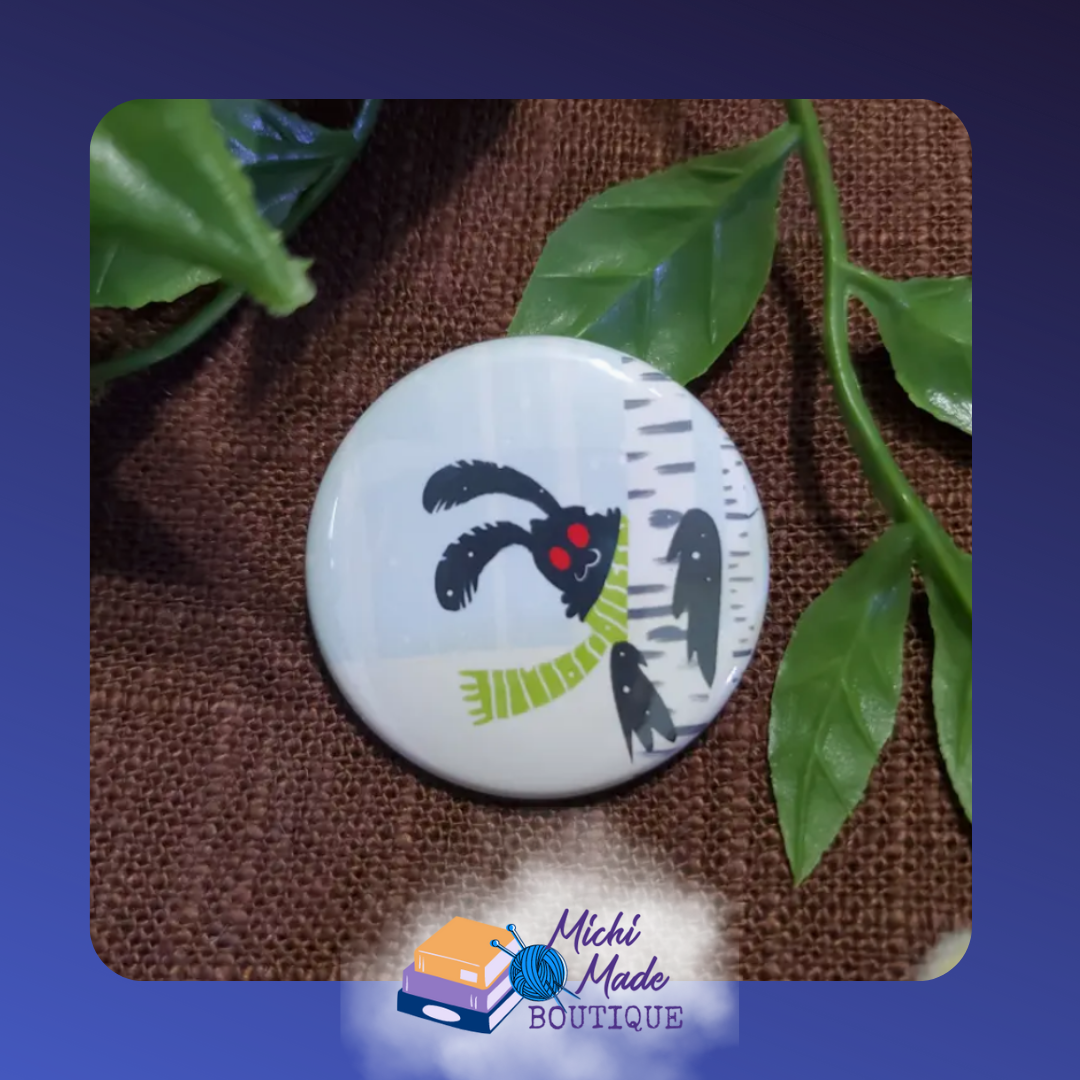 Winter Mothman Fridge Magnet – Mothman in green scarf hiding behind a birch tree in snowy forest.