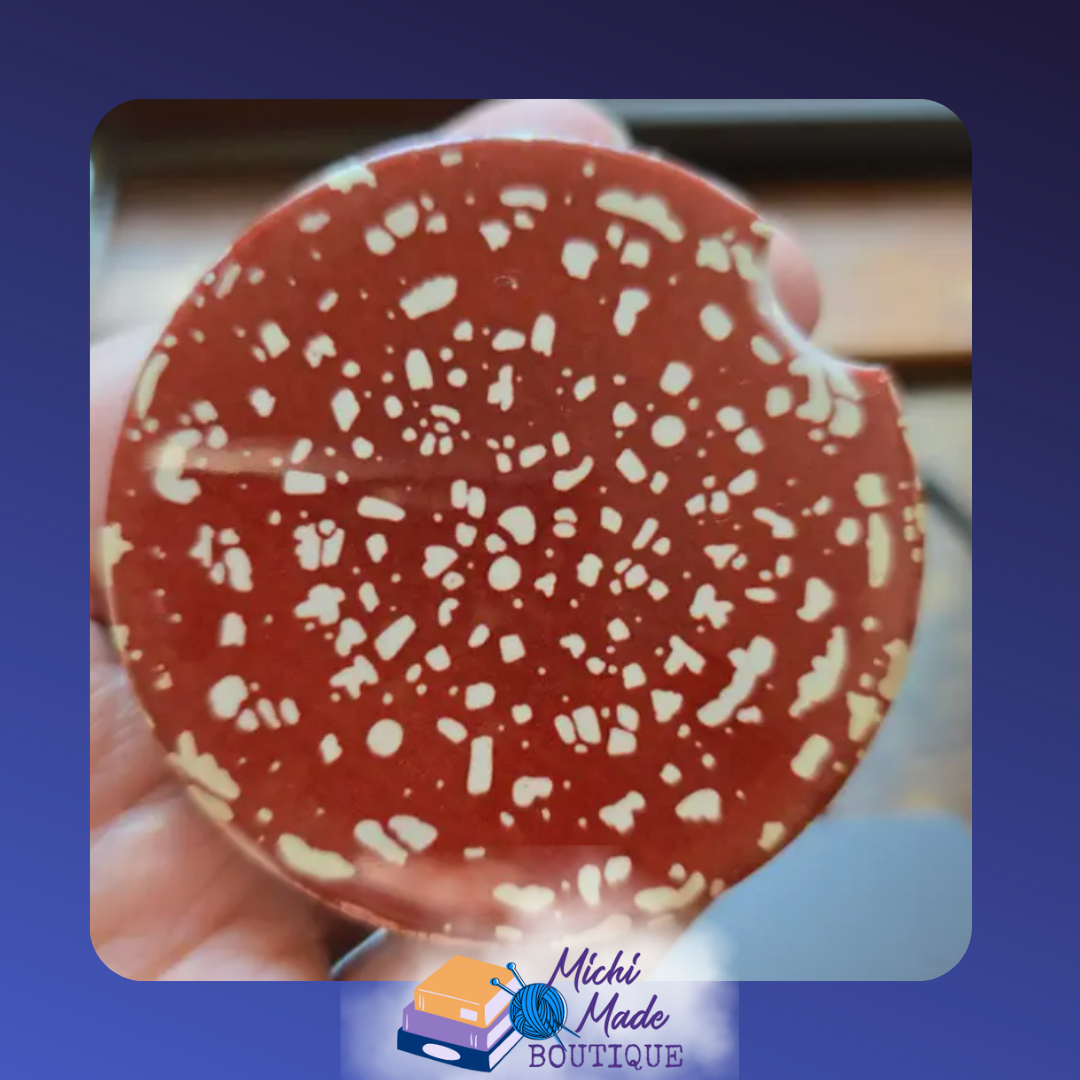 Ceramic car coaster with red mushroom cap pattern with cream spots.