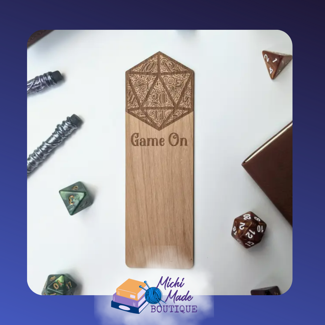 Game On: “Alder wood bookmark engraved with an ornate d20 crest and the words ‘Game On’ in a tabletop-themed flat lay.”