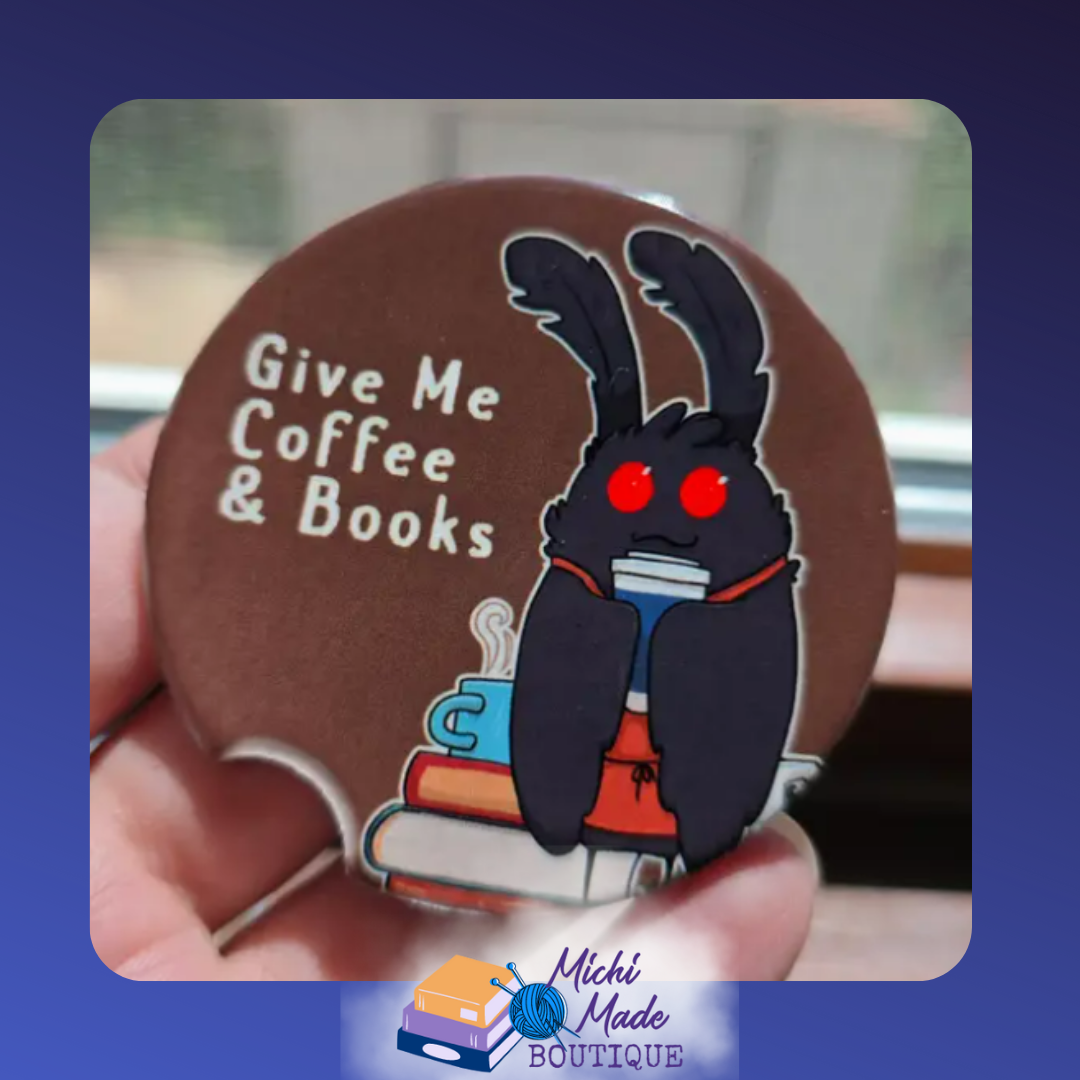 Ceramic car coaster with cartoon Mothman holding coffee and books, text reads “Give Me Coffee & Books.”