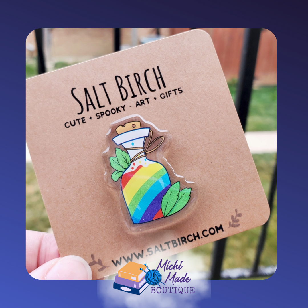 Acrylic pin of rainbow potion bottle with leaves.