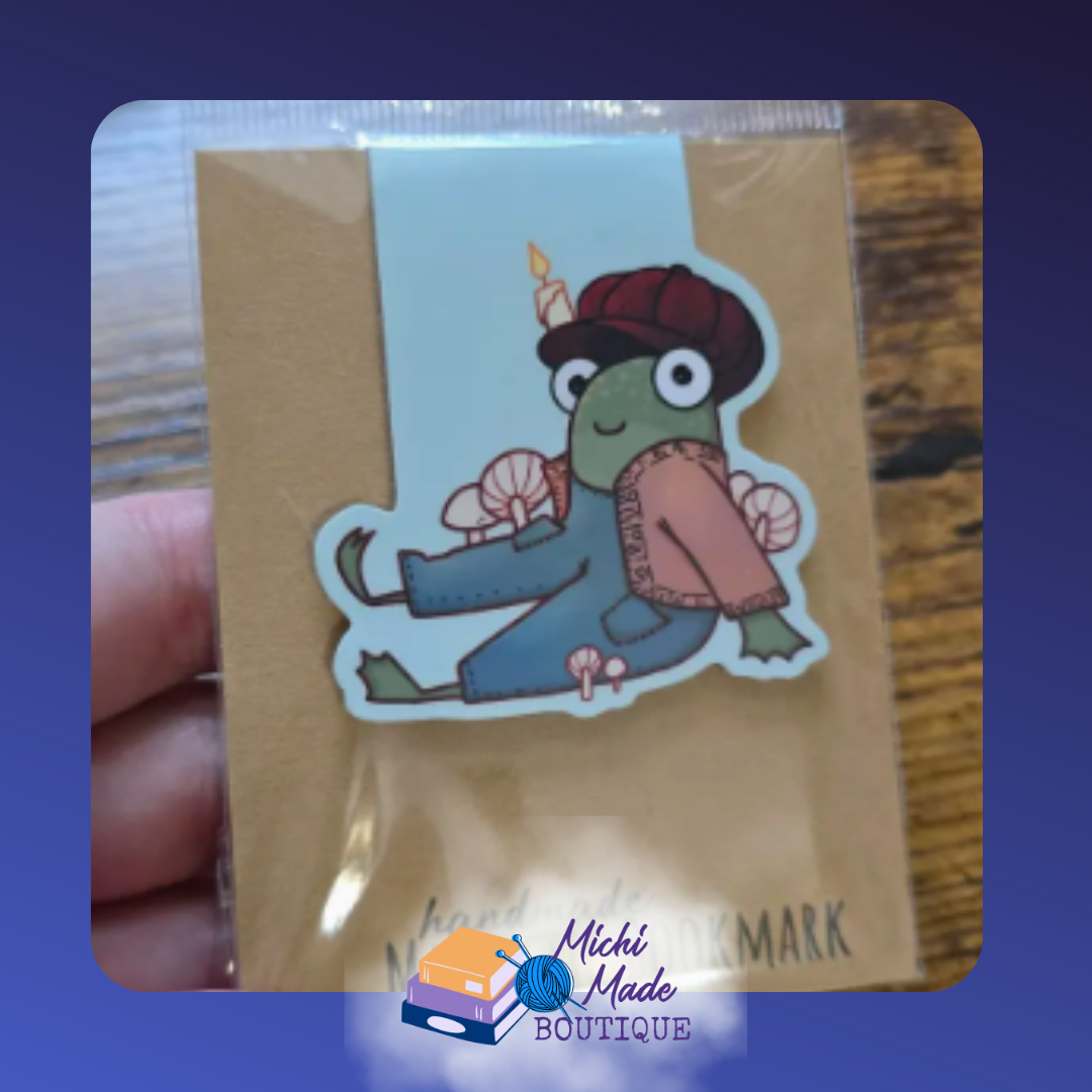 Frog wearing a straw hat and fall jacket with overalls. Mushrooms around him.