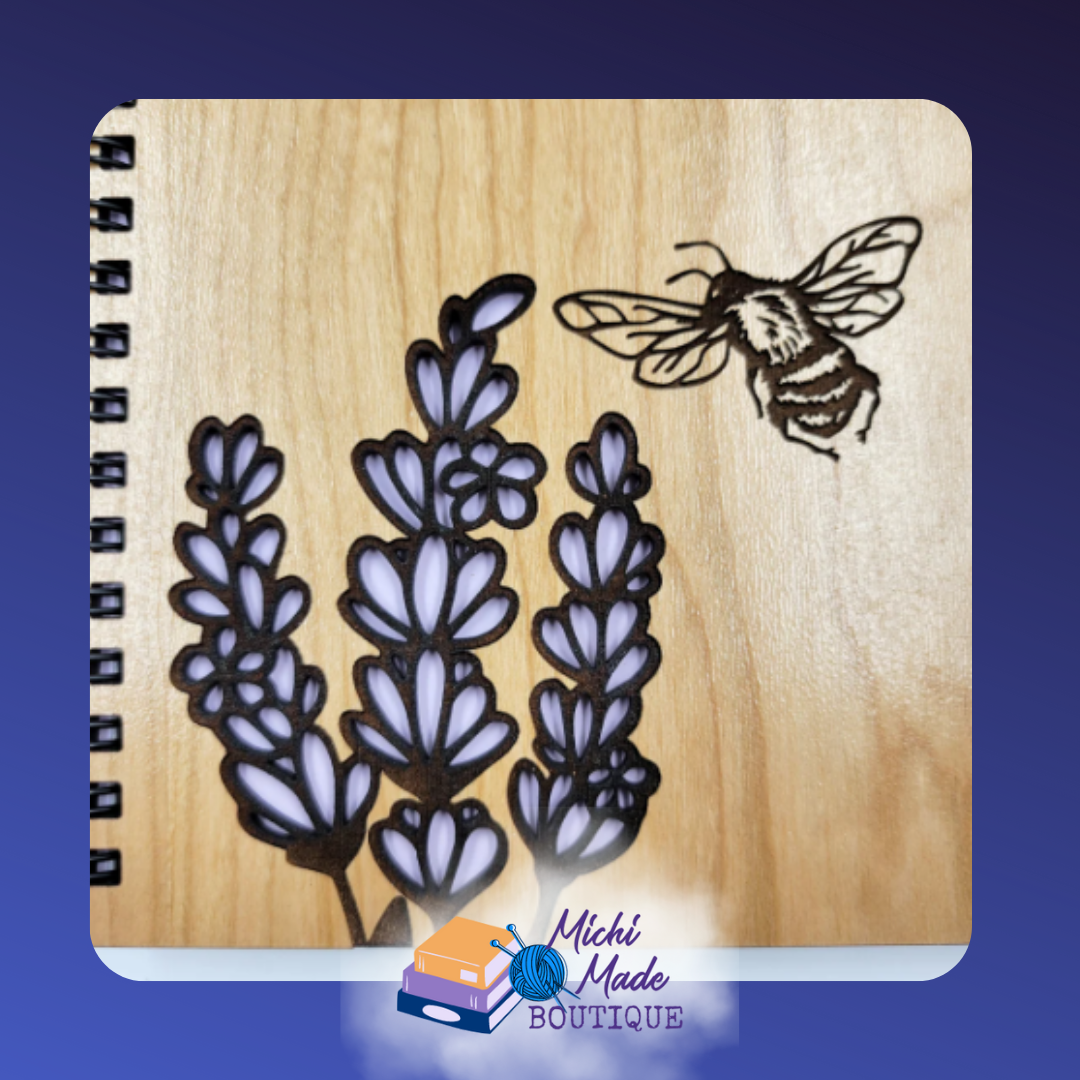 Close-up of lavender sprigs and bee engraving on wooden journal cover.