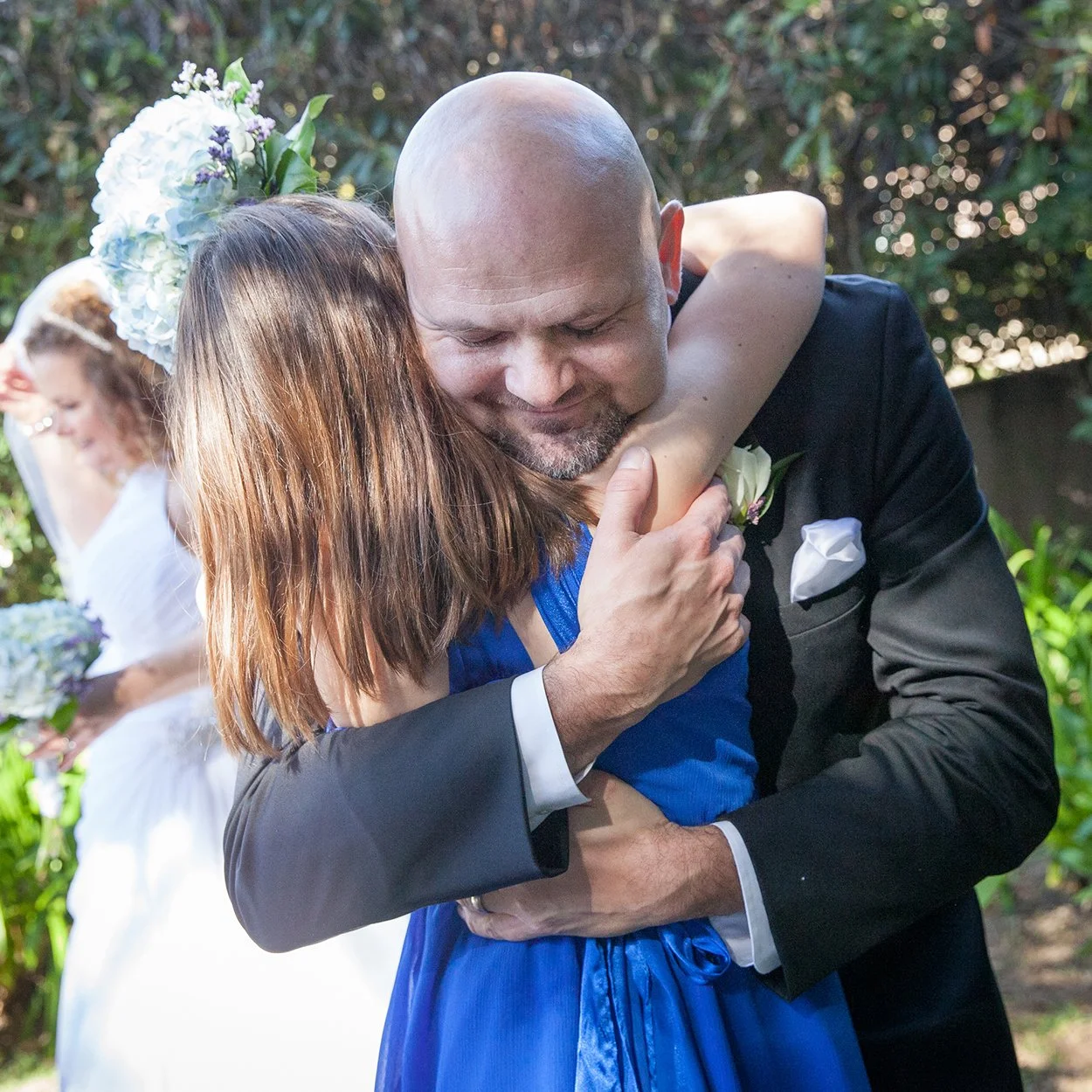 older-groom-father-hugging-bridesmaid-daughter-Santa-Barbara.jpg