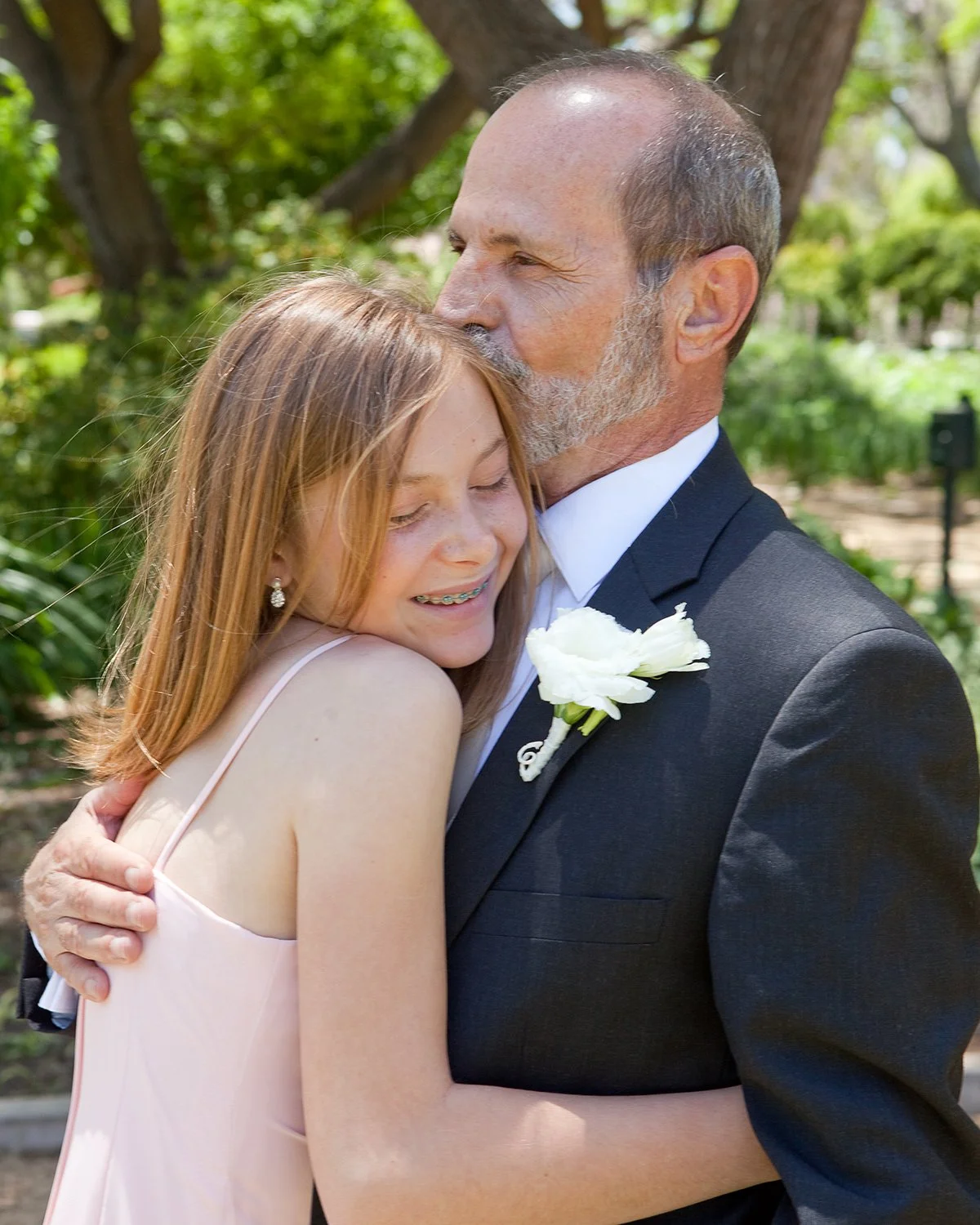 older-groom-kissing-stepdaughter-after-Santa-Barbara-wedding.jpg