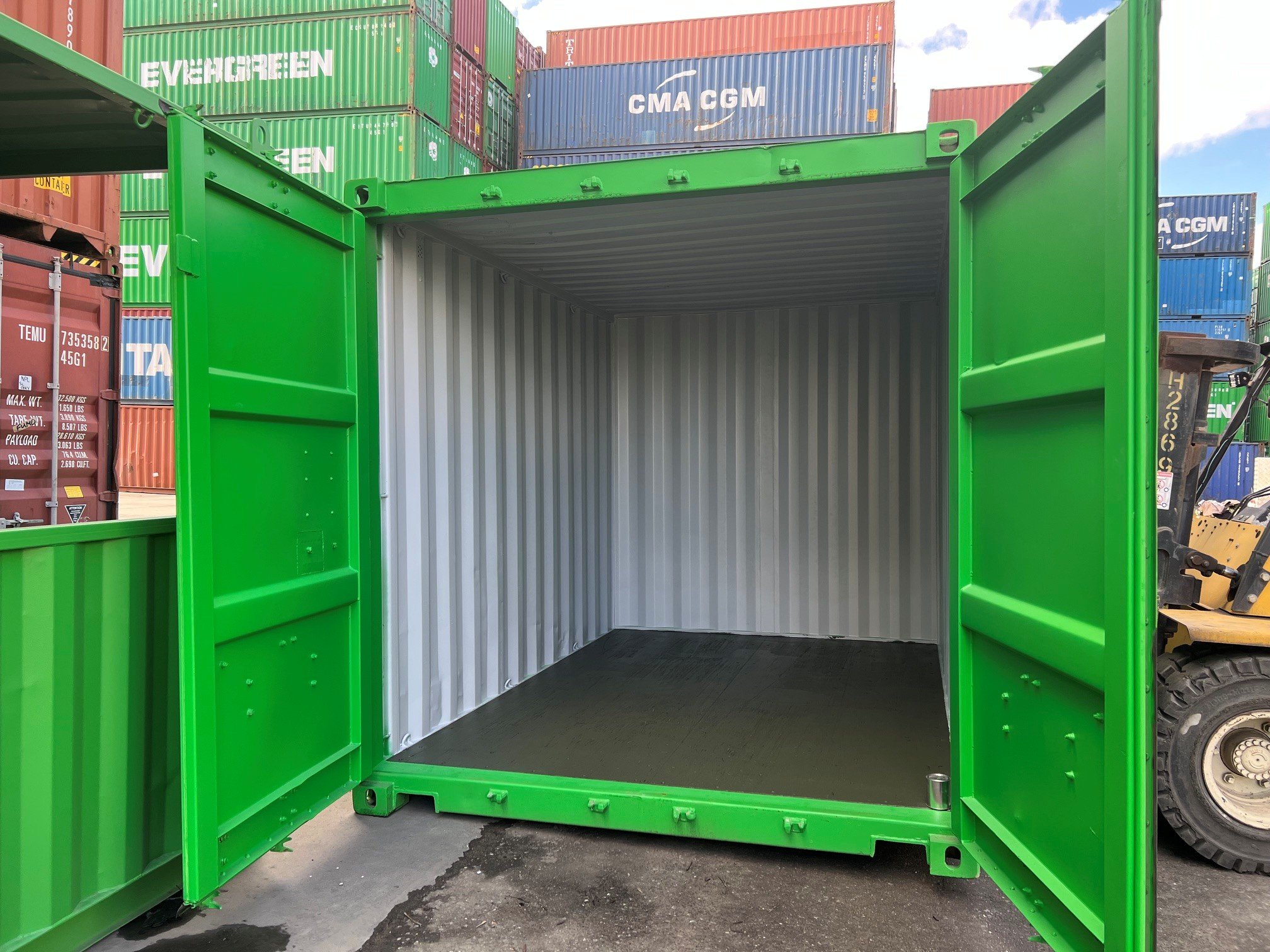 Empty 10ft green shipping container with original container doors open