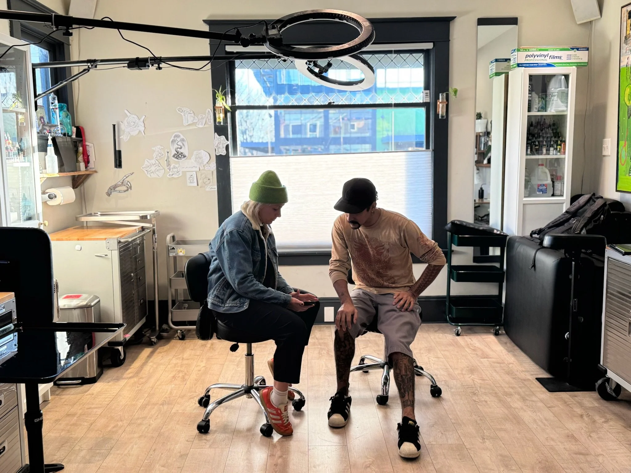 Indigenous tattoo artist and Native client consult on ideas at tattoo shop Tattoo 34 in Portland, Oregon 