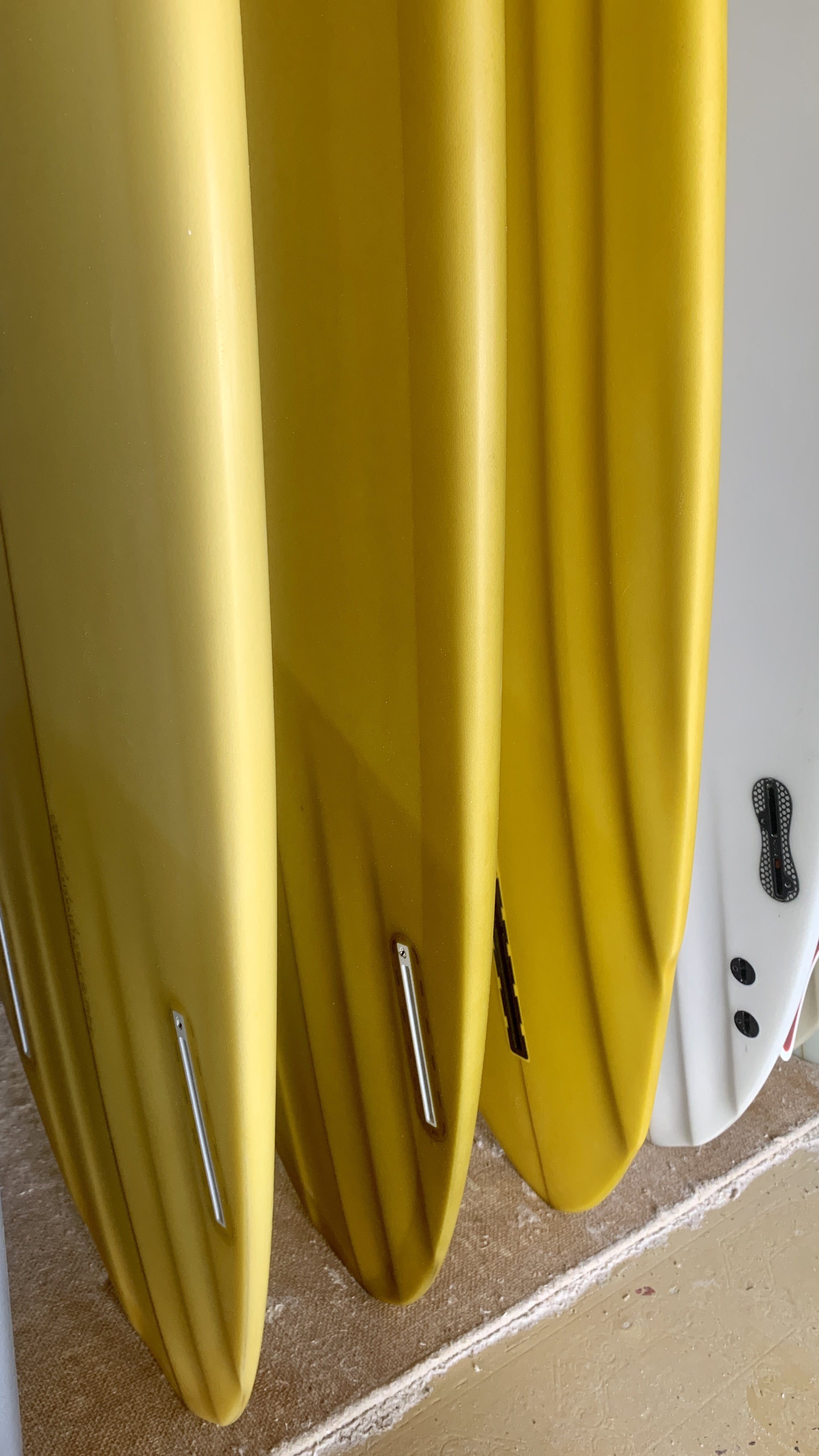 Close-up of yellow and white surfboards standing upright