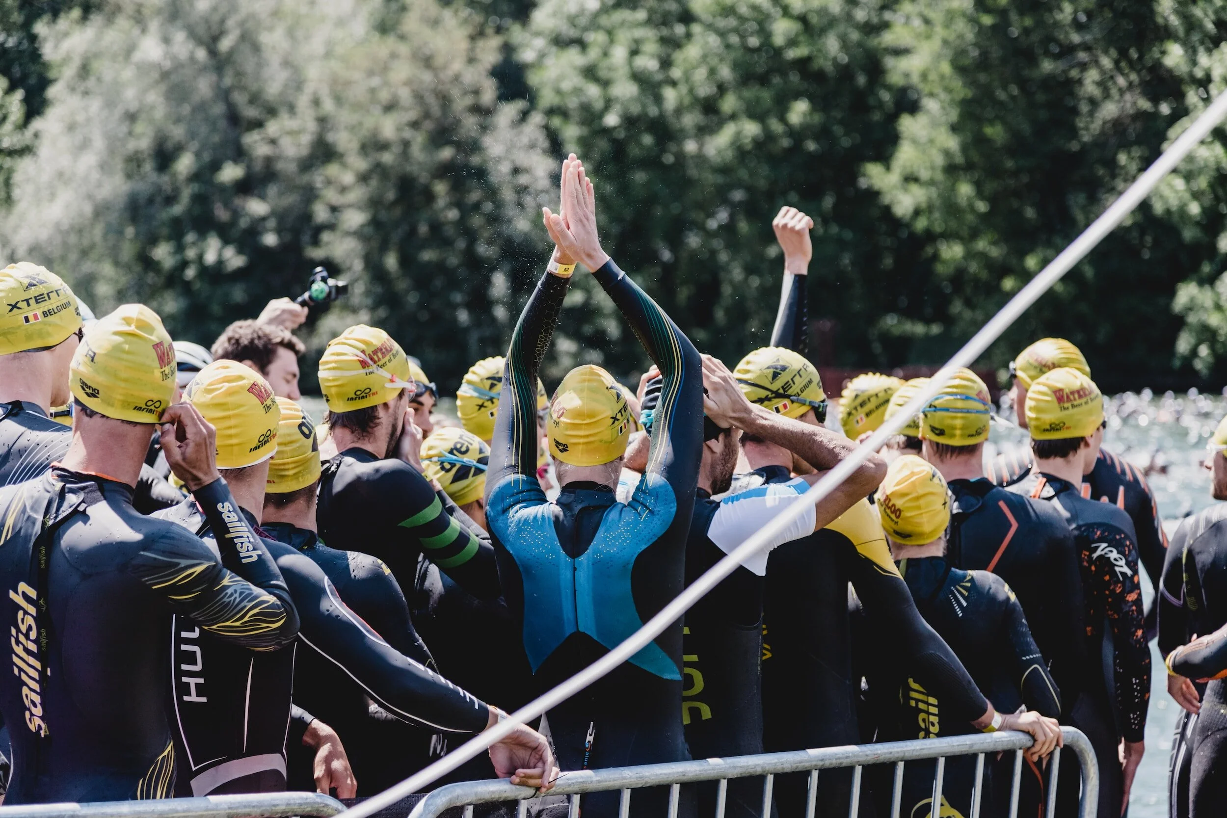 triathletes lining up in wetsuits to start swimming
