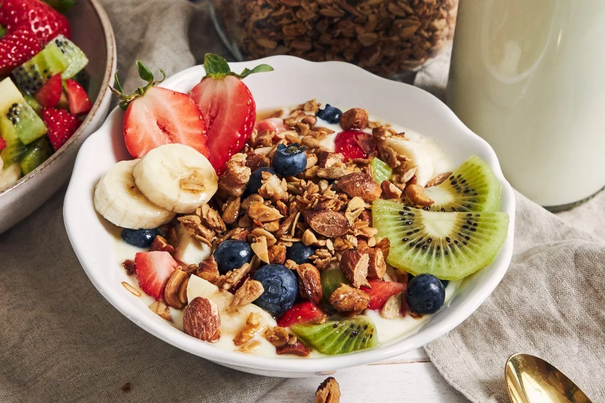 Granola and fruit yogurt bowl with nuts on the table