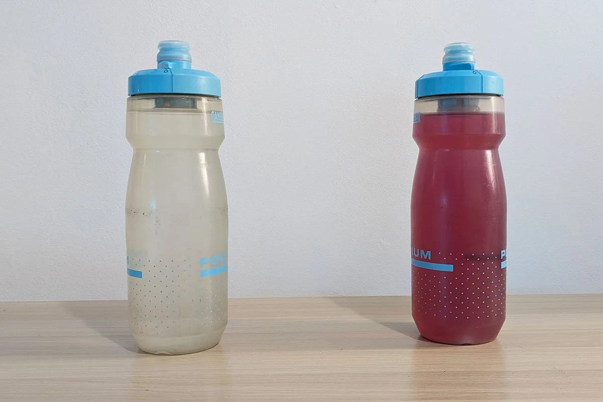 Two sport bottle are standing on the table