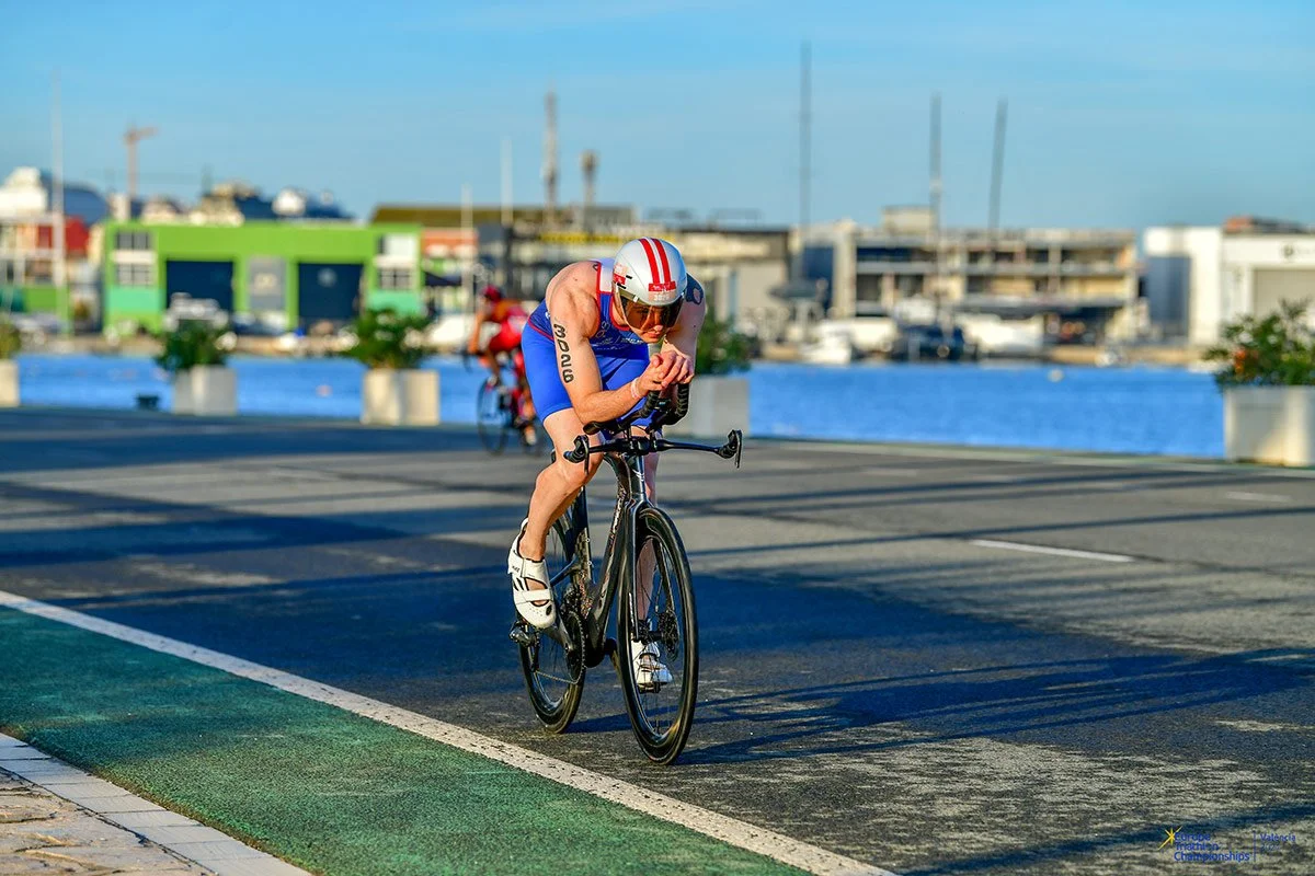 A triathlete is riding a bike on the competition