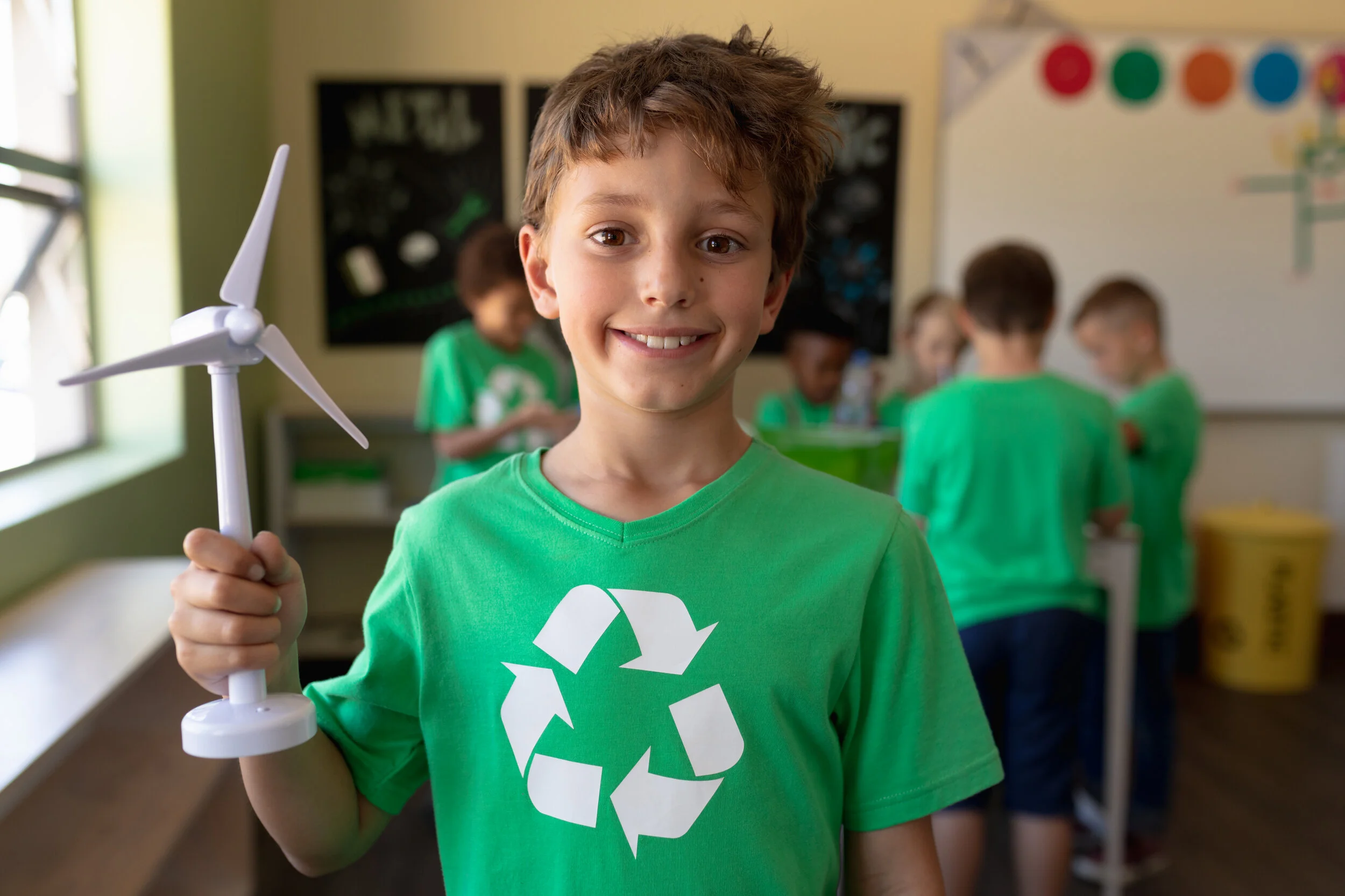Photograph of a child holding a model wind turbine