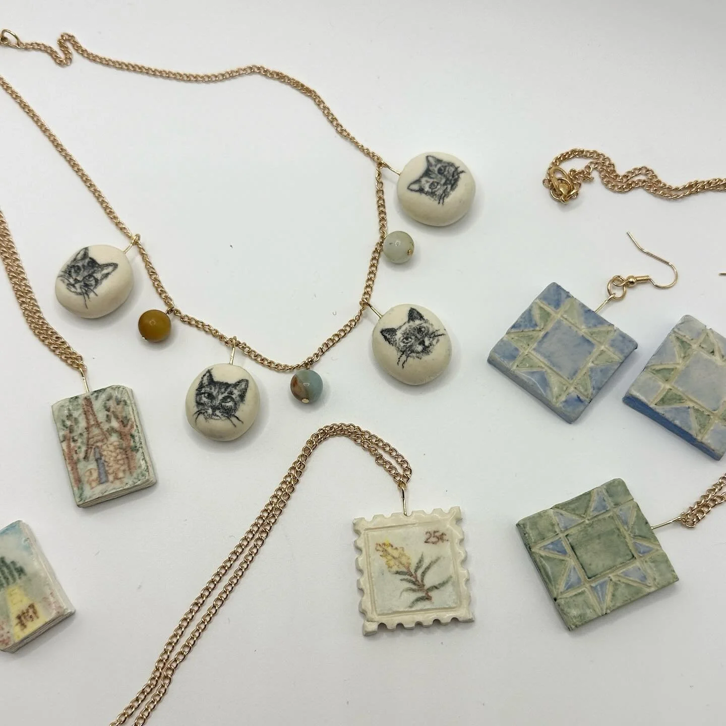 Here&rsquo;s the rest of the ceramic jewelry I made in July!

-Matching quilt square earrings + necklace 🛏️
-Madeline + Wizard of Oz book covers 📖 
-Goldenrod postage stamp 🌾

#ceramicjewelry #ceramiccharms #charmnecklace #charmjewelry