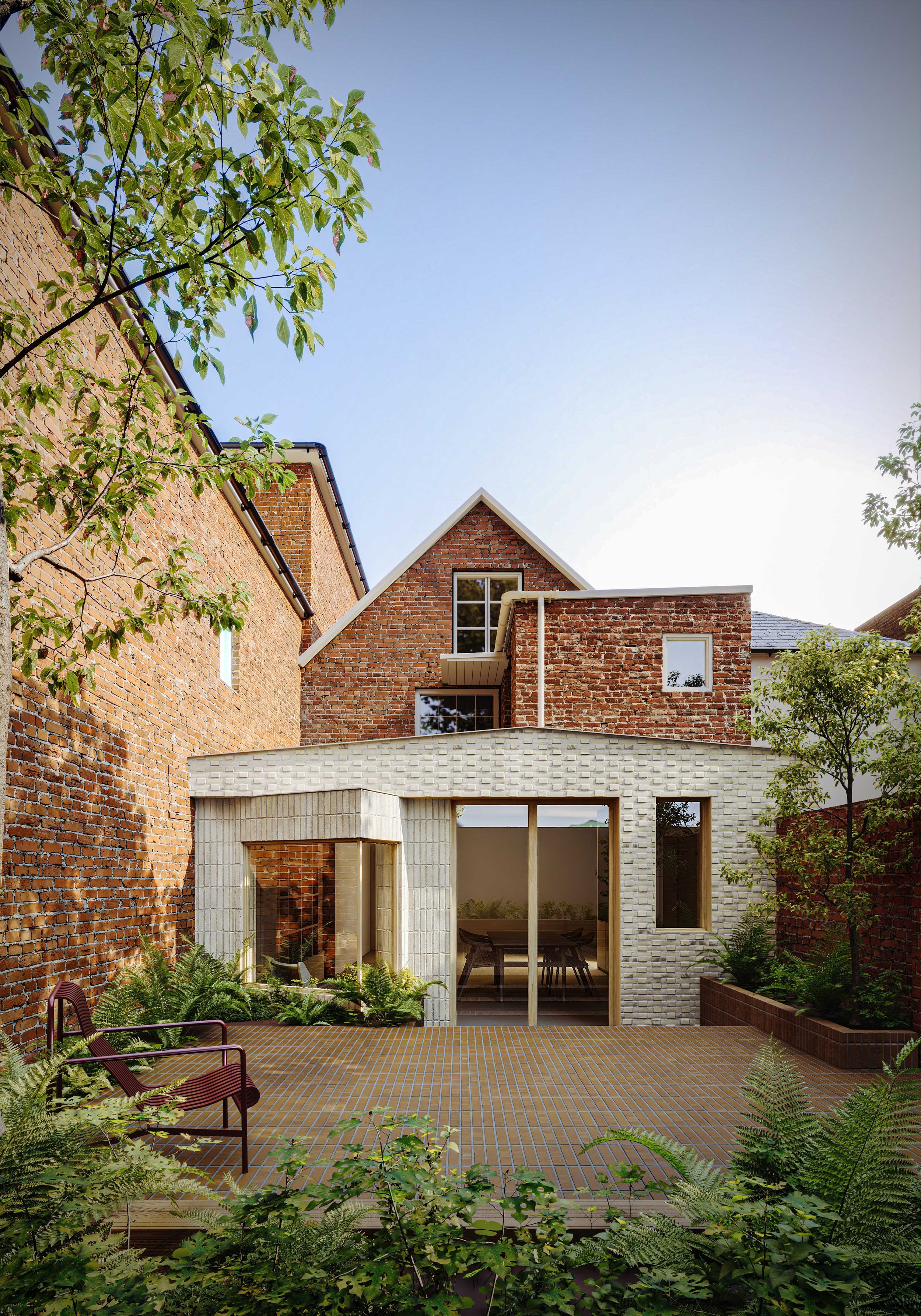 Contemporary pale-brick extension to Fuchsia Cottage in Seaview, contrasting with the existing red-brick house and opening onto a secluded courtyard garden.