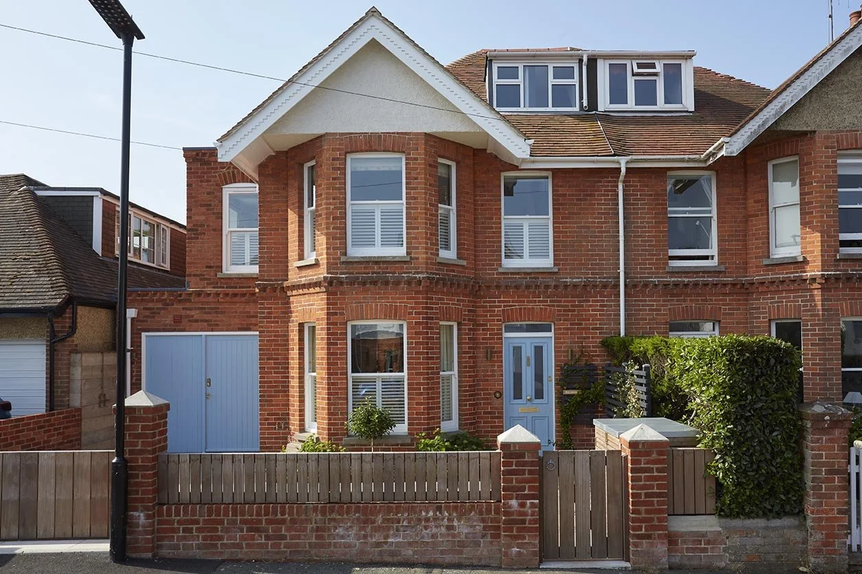 Traditional red-brick Victorian and Edwardian seaside house in Seaview, Isle of Wight, with bay windows, a blue front door and roof dormer.