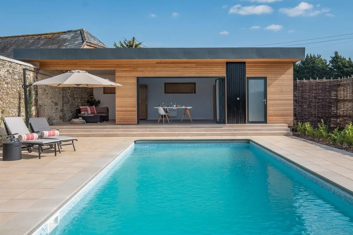 Contemporary pool house at Wacklands Farmhouse, Newchurch, Isle of Wight, designed by Mattinson Associates to complement the historic buildings and listed architectural setting of the rural estate.