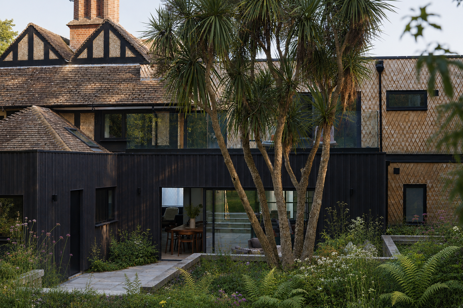 Contemporary black timber extension on traditional tudor inspired building isle of wight