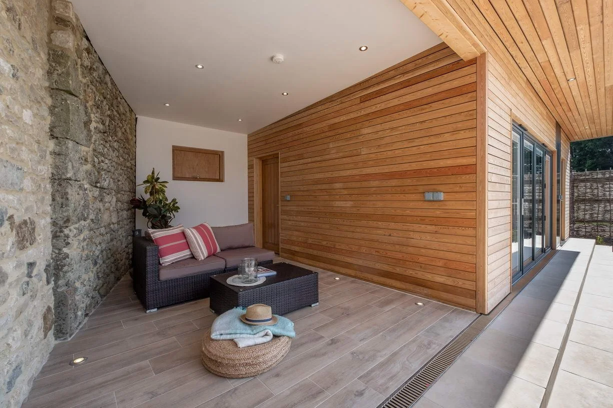 Pool house and outdoor leisure space at Wacklands Farmhouse, integrating contemporary architecture with landscaped gardens and the established rural setting of this Isle of Wight estate.