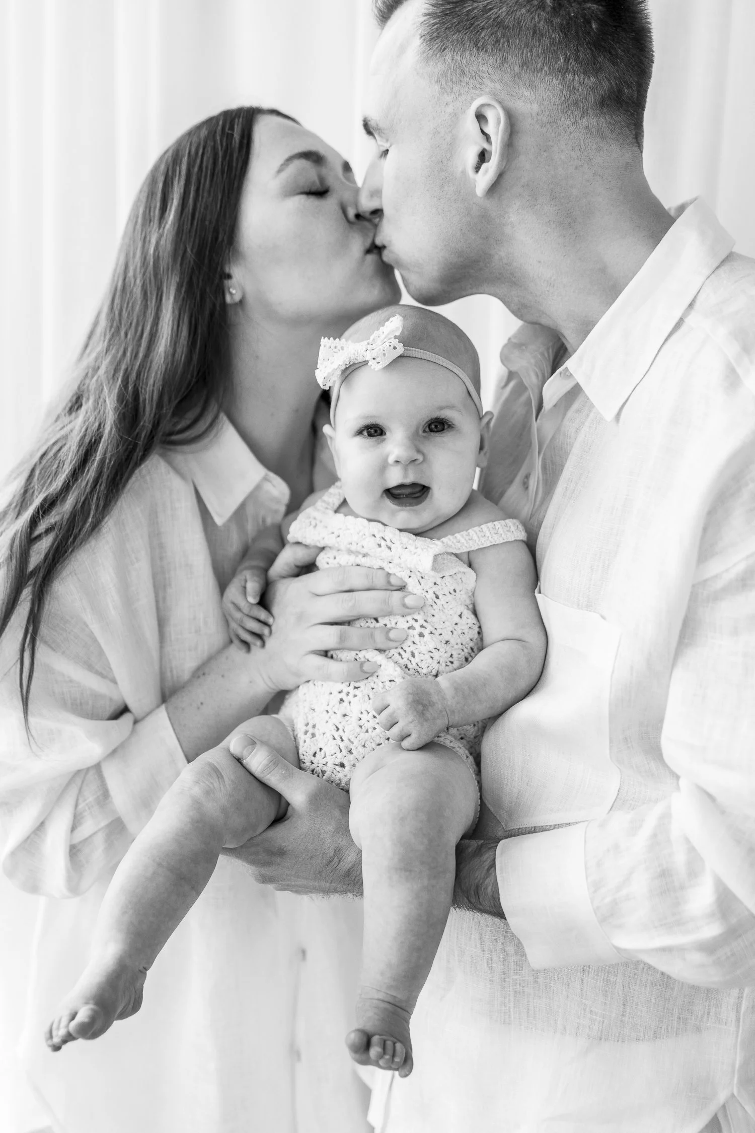 family photoshoot of baby being loved on by parents