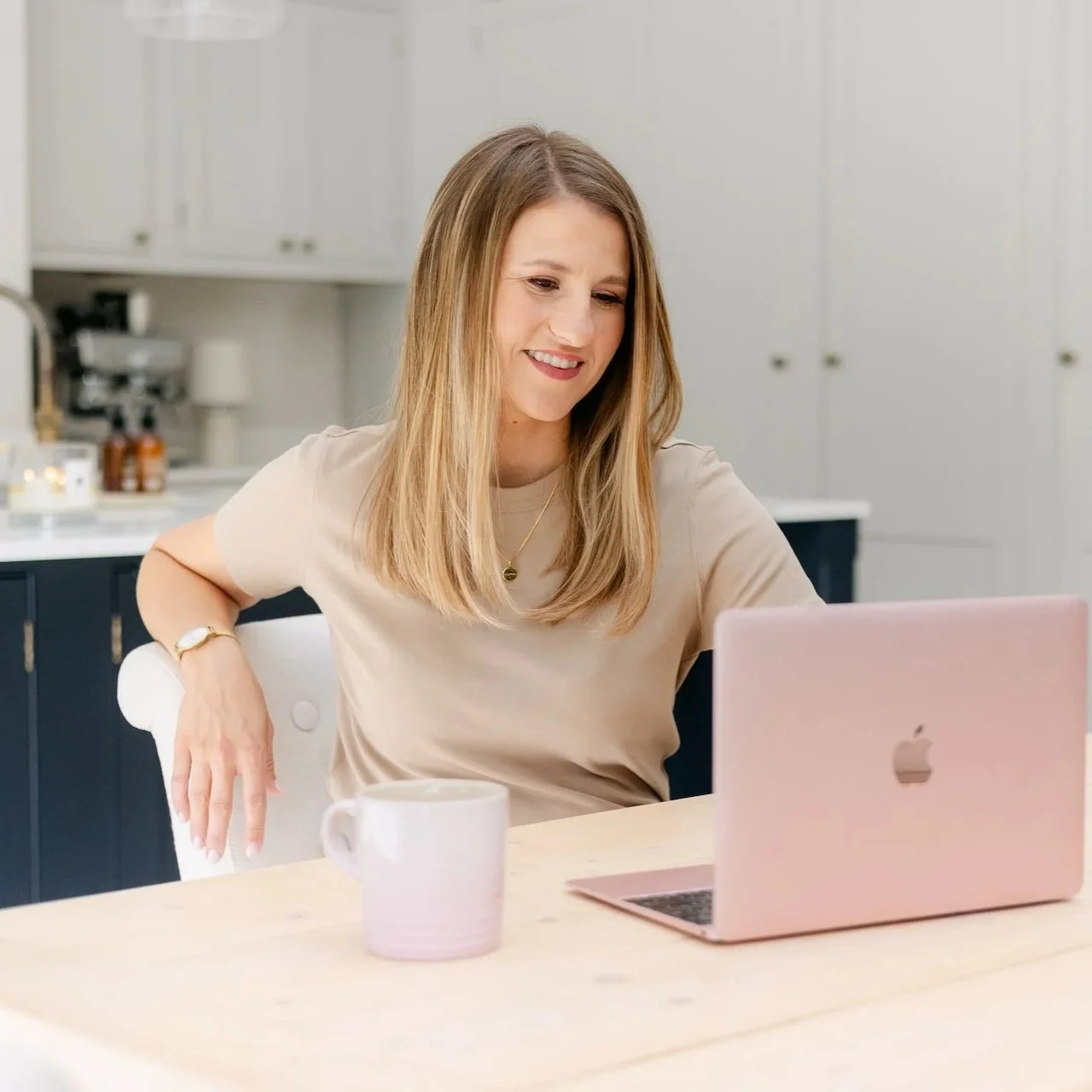 Business coach for mothers working at a laptop in a home workspace