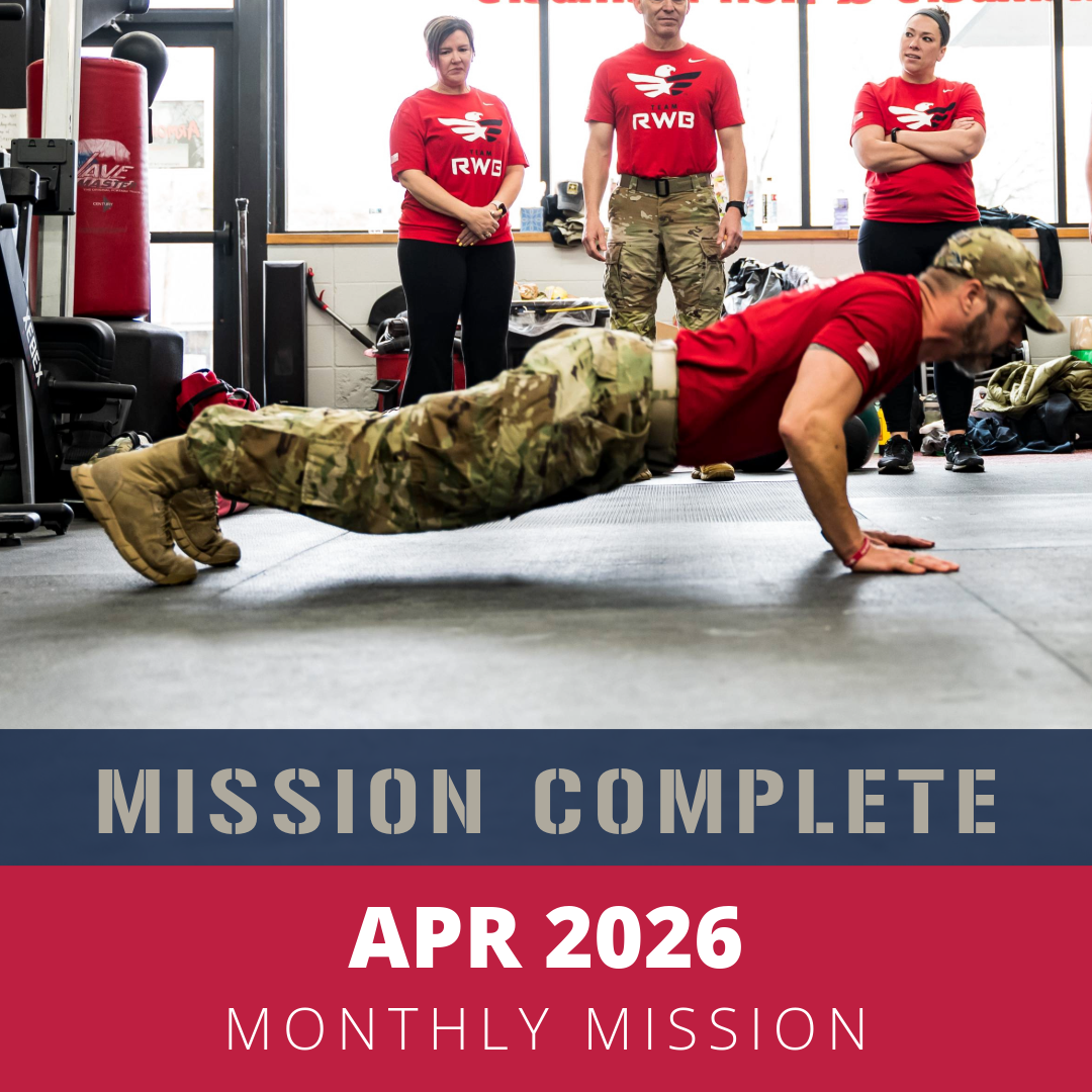 A man in military camouflage pants doing push-ups on the gym floor, with three women in red shirts watching him.
