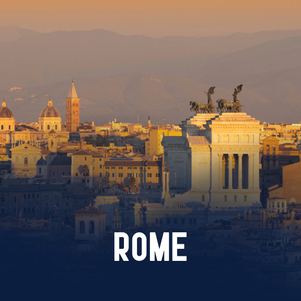 Sunset view of Rome with historic buildings and sculptures, including the Victor Emmanuel II Monument.