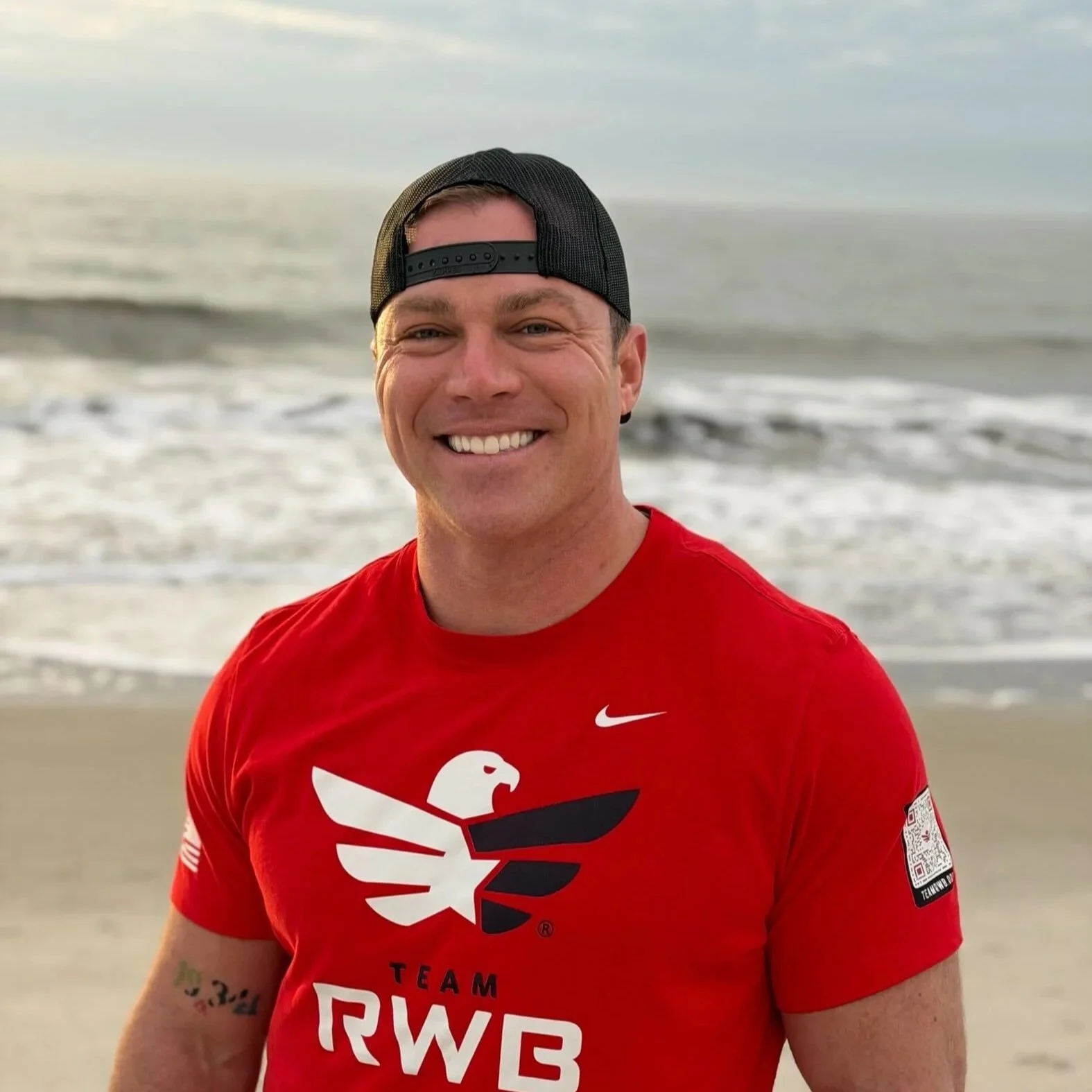 Logo of Team RWB featuring a stylized eagle with wings in red and white on a navy blue background, with the words 'TEAM RWB' below.