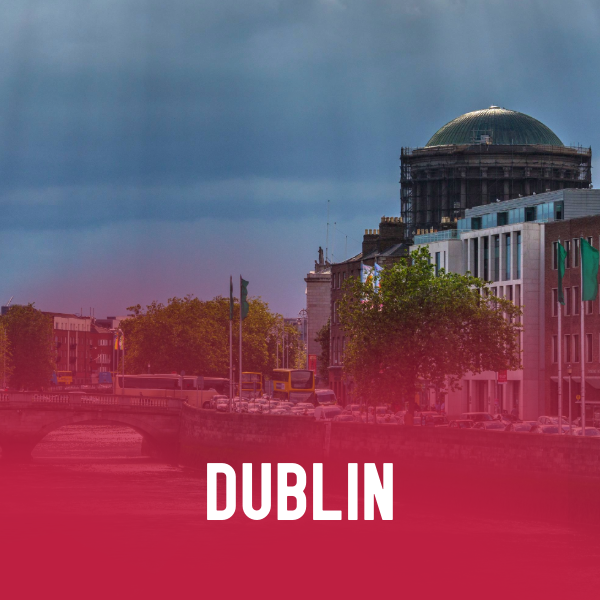 View of a cityscape in Dublin, Ireland, with historic and modern buildings, a river, and a bridge under a cloudy sky, with 'Dublin 2026' text overlay.