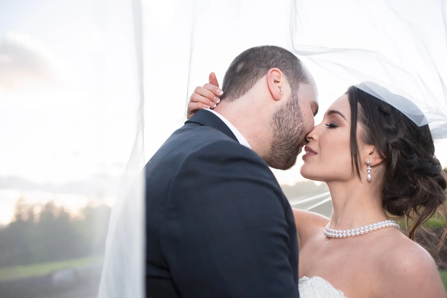 The bride and groom sharing a kiss under her veil