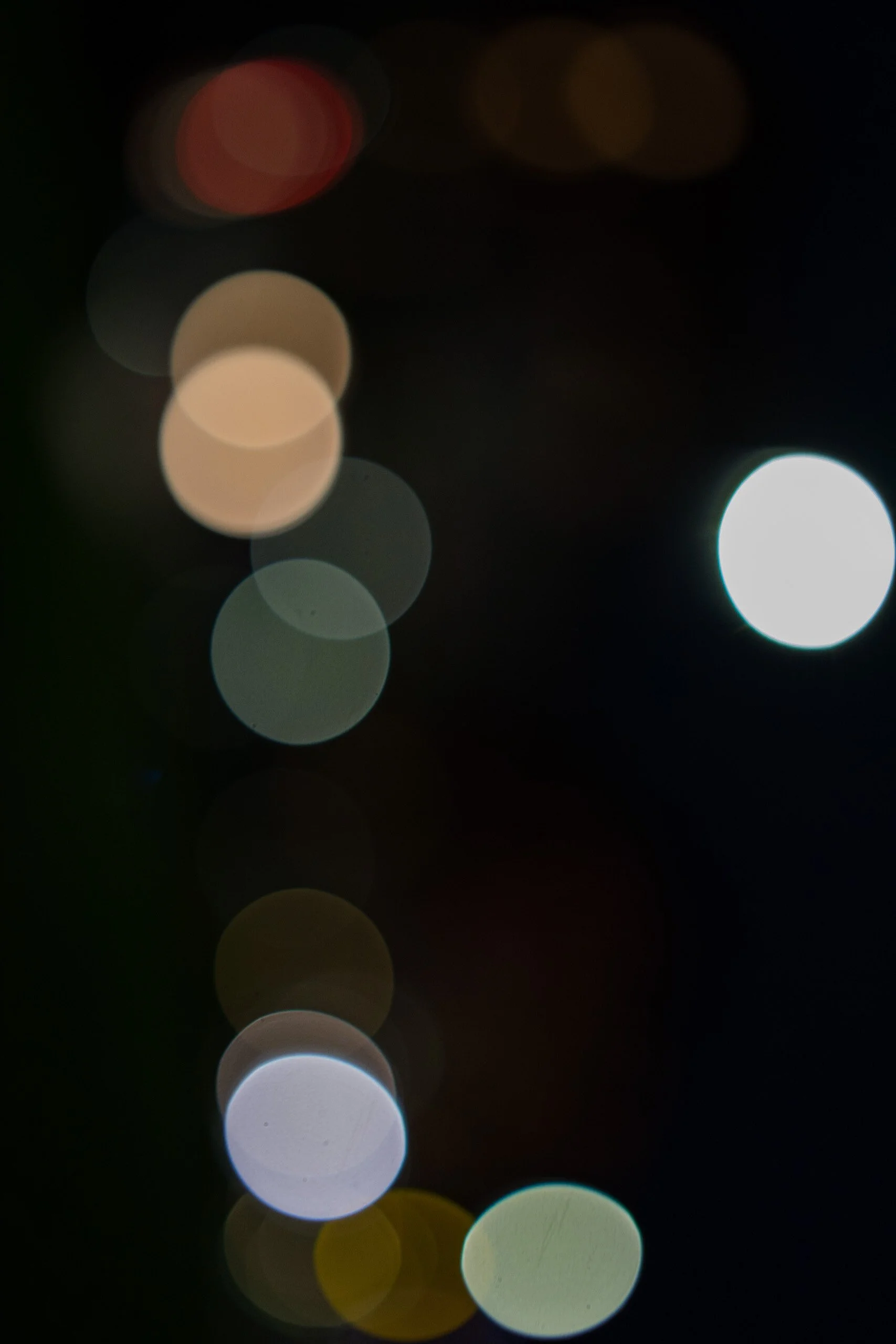 Out-of-focus bokeh lights in various colors against a dark background.